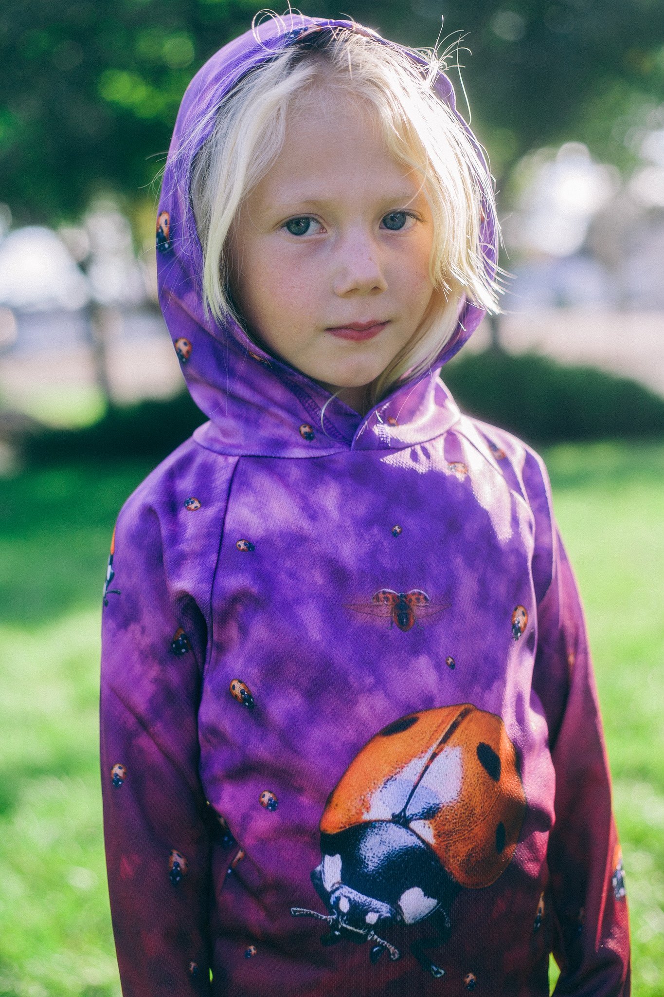 A vibrant LADYBUG Hoodie Chomp Shirt featuring colorful ladybug designs on a soft, lightweight fabric, perfect for outdoor activities.