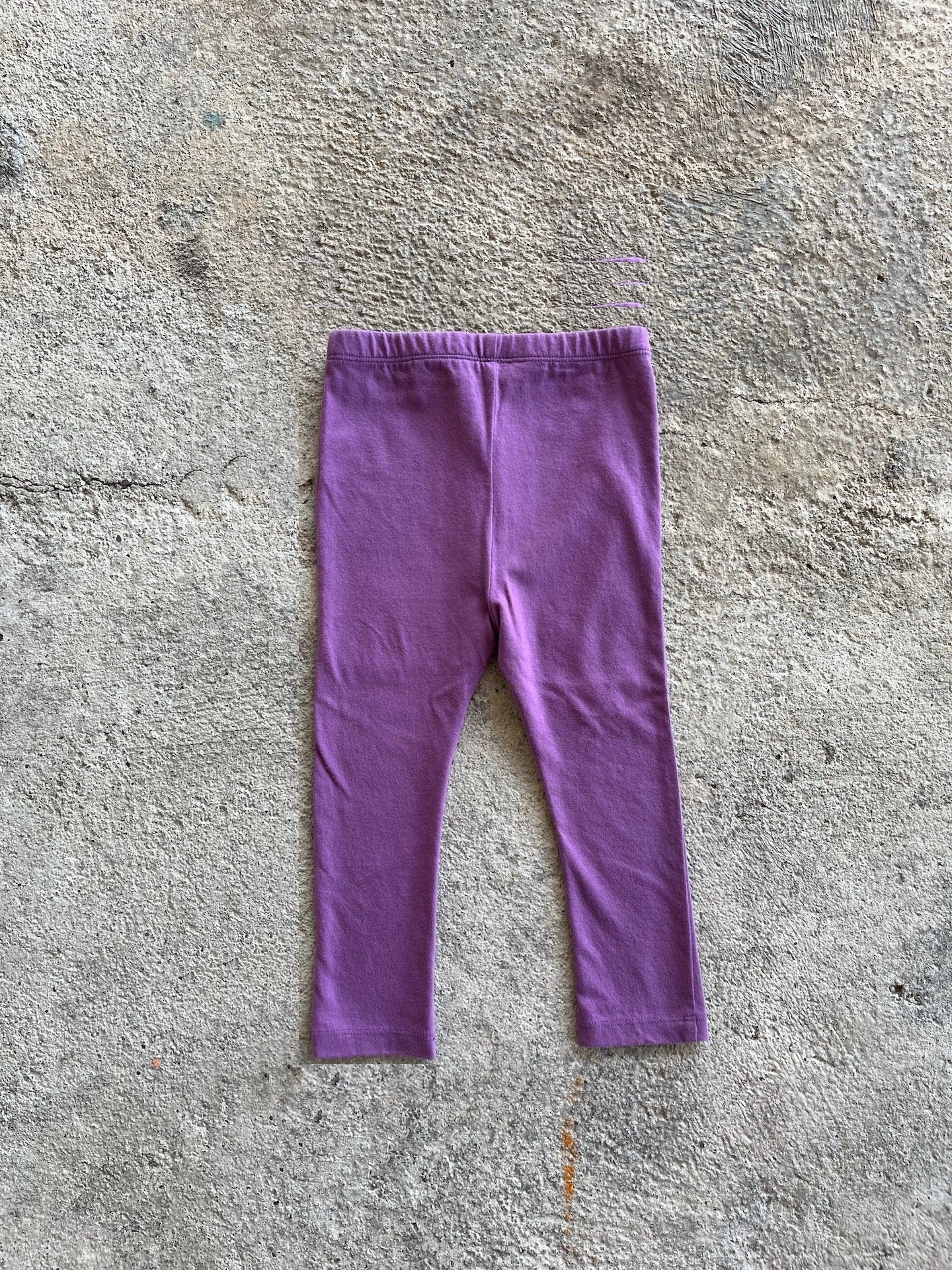 A pair of purple leggings for babies and toddlers, featuring an elasticised waist and made from soft organic cotton.