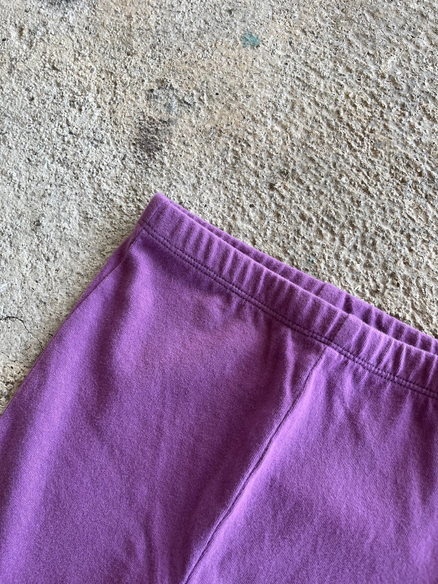 A pair of purple leggings for babies and toddlers, featuring an elasticised waist and made from soft organic cotton.