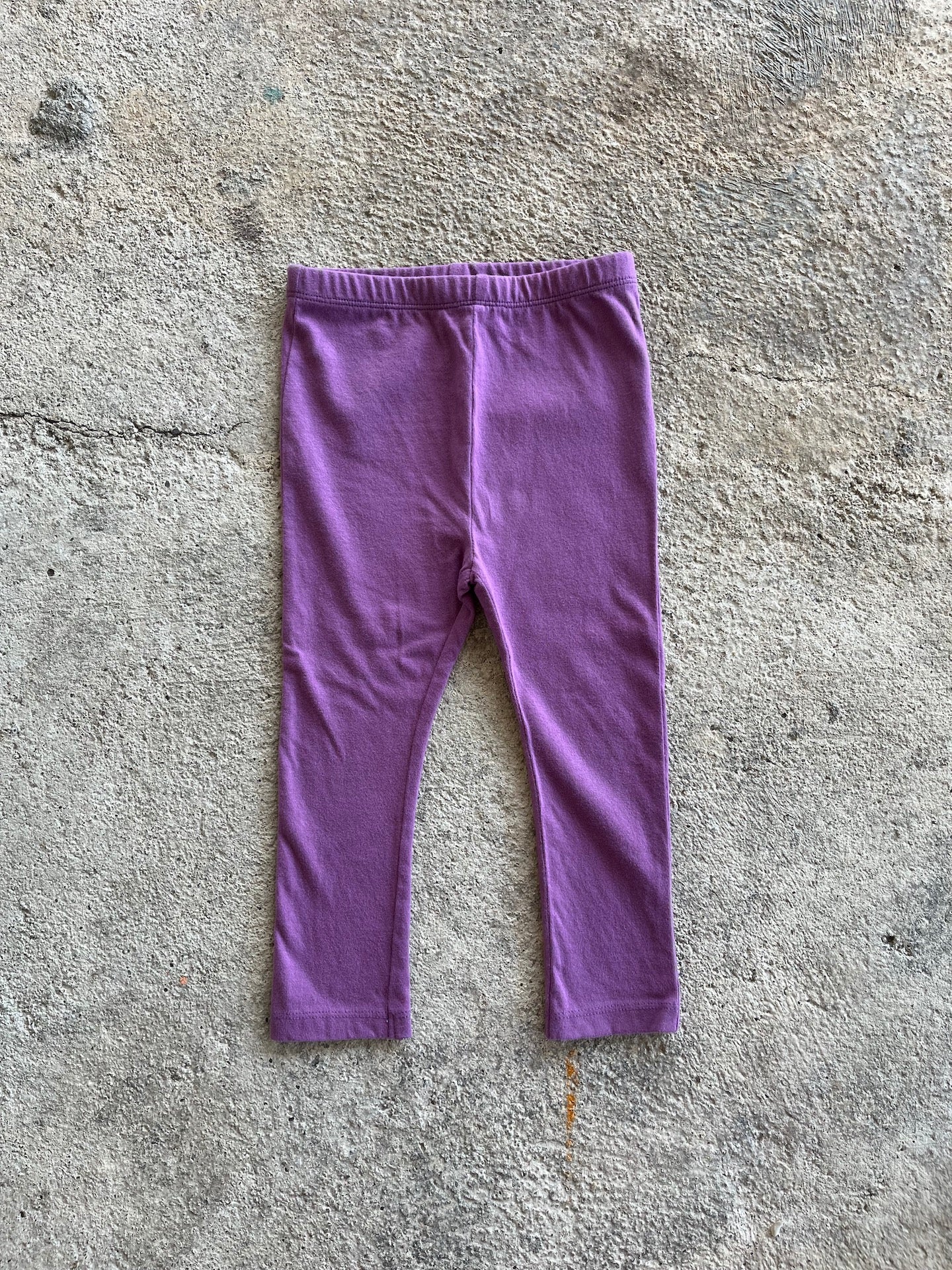 A pair of purple leggings for babies and toddlers, featuring an elasticised waist and made from soft organic cotton.