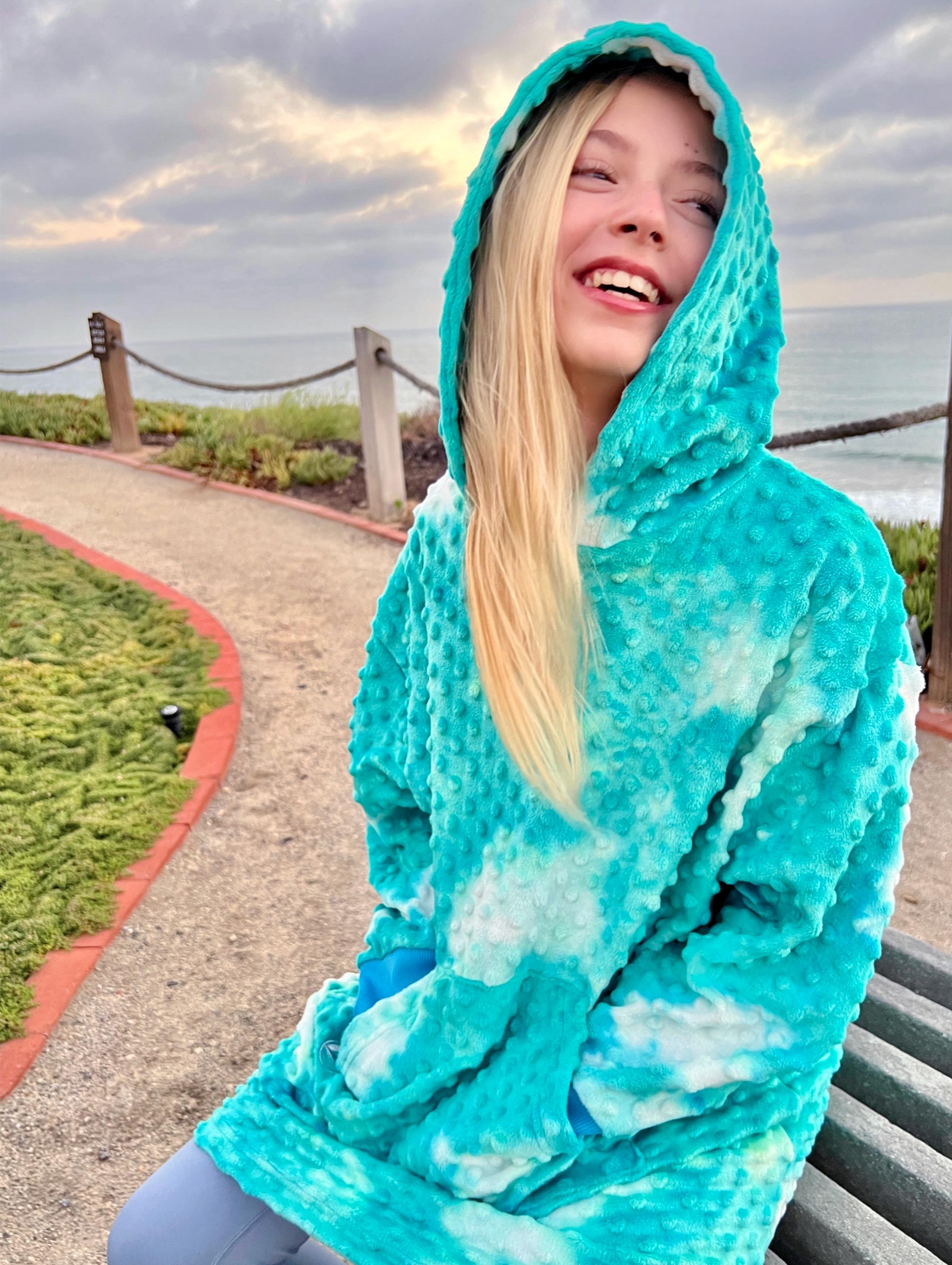 Girls oversized hoodie in turquoise tie-dye, made from ultra-soft Minky fabric, featuring a large pocket and ribbed cuffs.