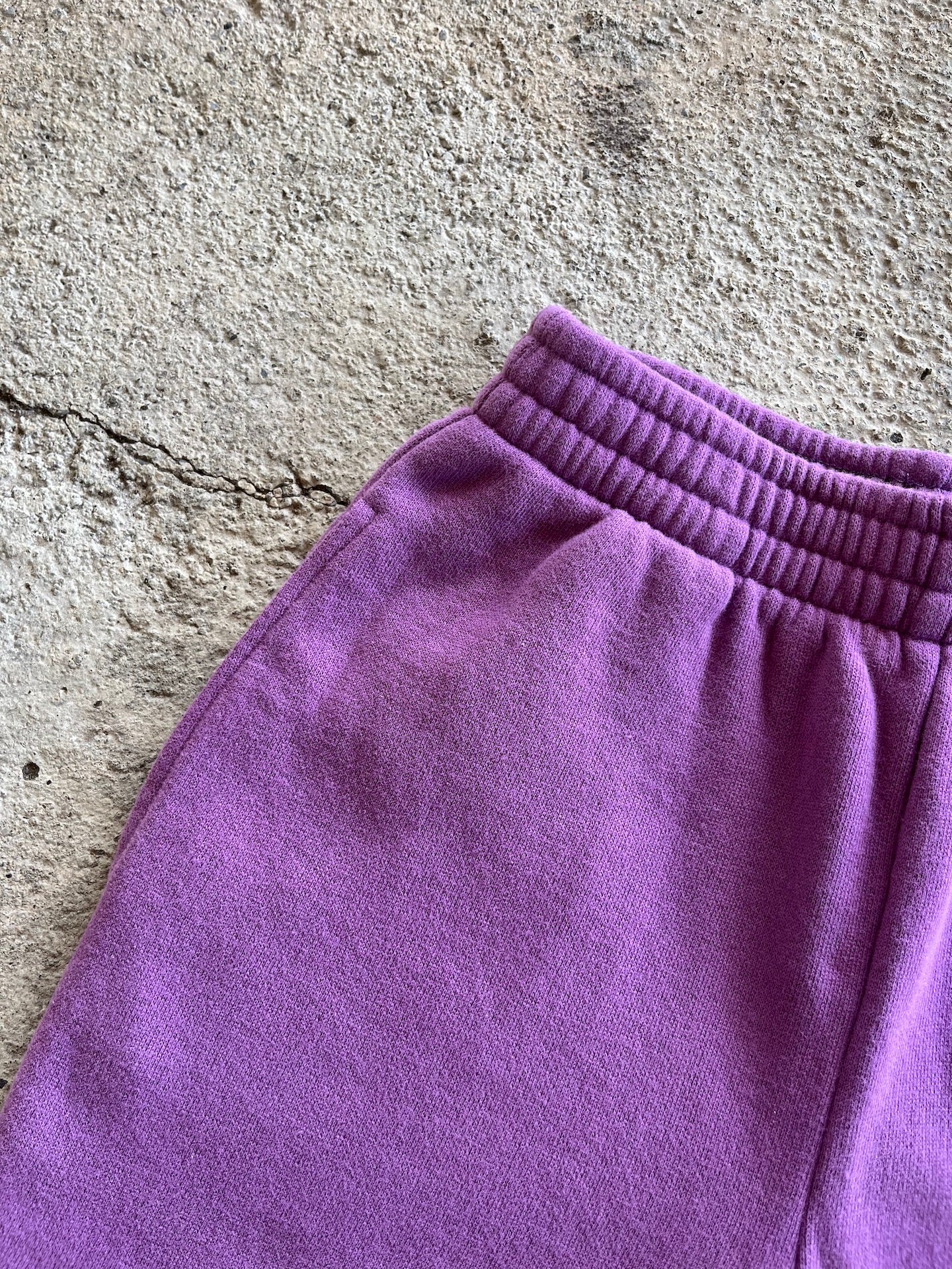 Warm and casual kids' pants in orchid color made from soft brushed cotton fleece with elasticised waist and side pockets.