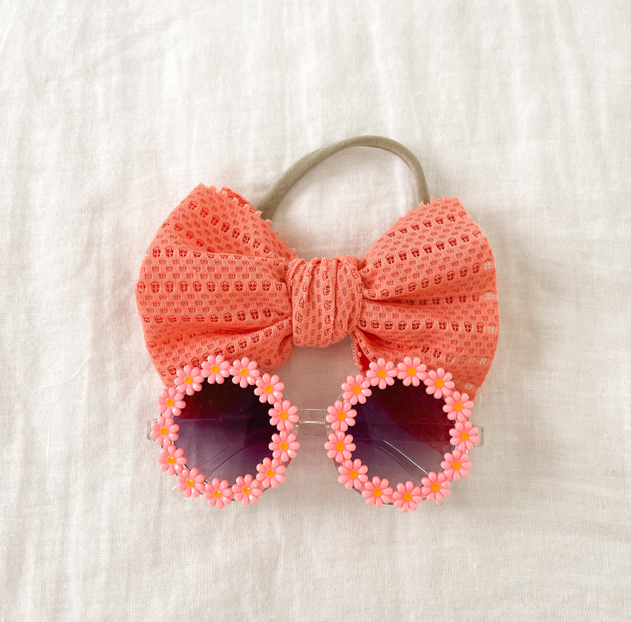 A vibrant set of Pink Sunflower sunglasses paired with a matching bow headband, perfect for summer outings.