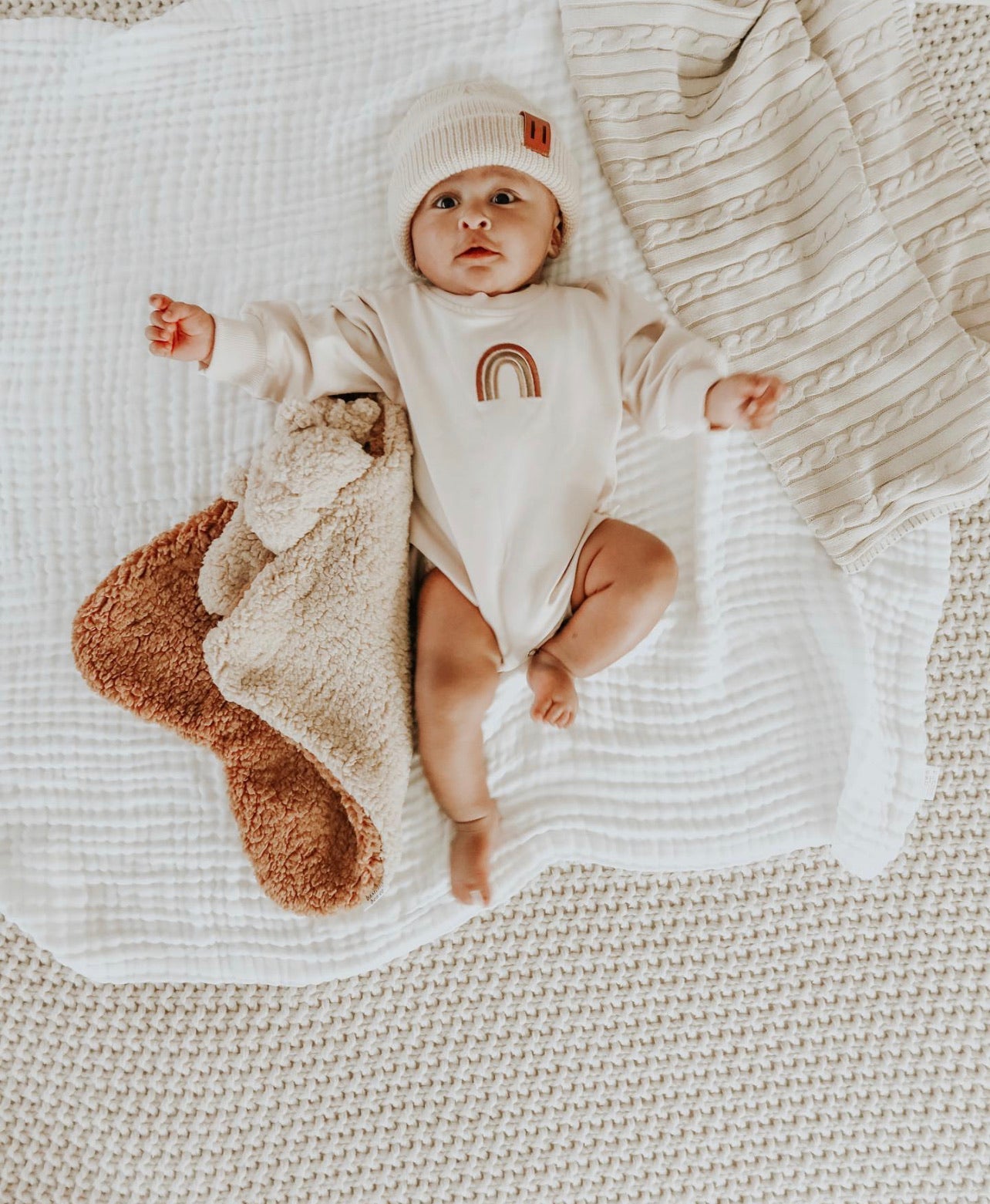 A stylish Rainbow White Sweater Romper made of soft cotton, featuring a playful rainbow pattern.