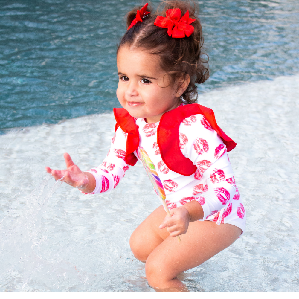 Red Kisses One Piece Kids Swimwear featuring vibrant print and UV protection, perfect for beach and pool activities.