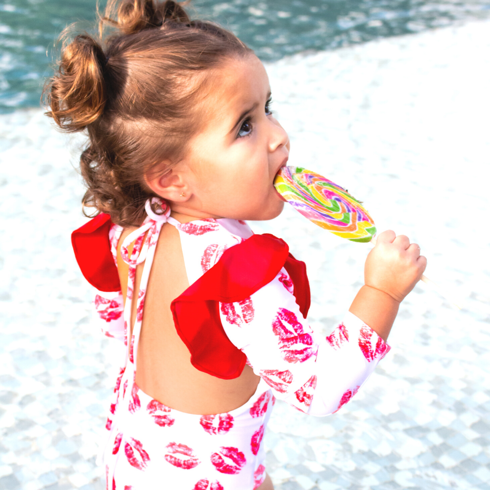 Red Kisses One Piece Kids Swimwear featuring vibrant print and UV protection, perfect for beach and pool activities.