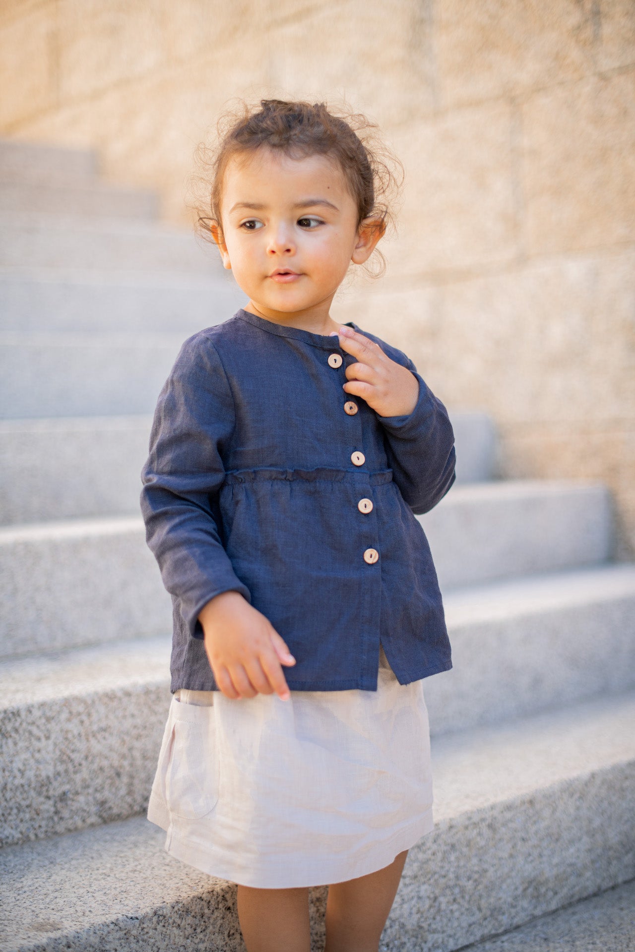 Casual long-sleeved blue linen shirt with frills and olive wood buttons.