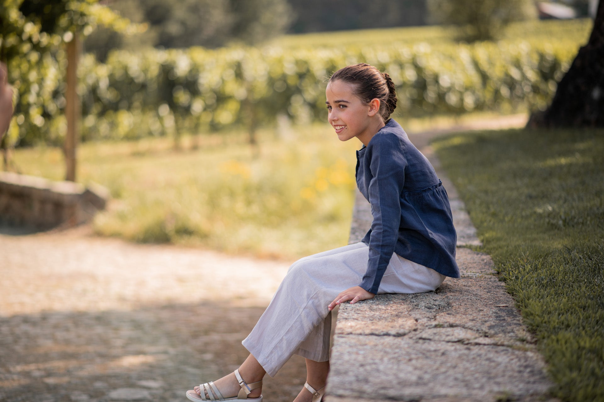 A casual long-sleeve shirt in violet blue with olive wood buttons and a frilled elasticised waist, made from lightweight linen fabric.