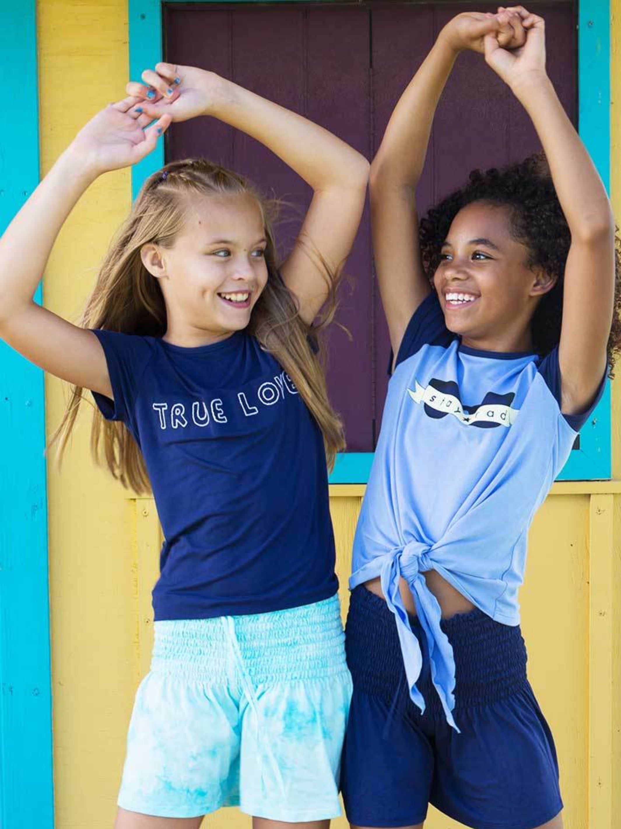 FRIEDA - STAY RAD GRAPHIC TEE featuring a relaxed fit, decorative front tie, and vibrant graphic design.