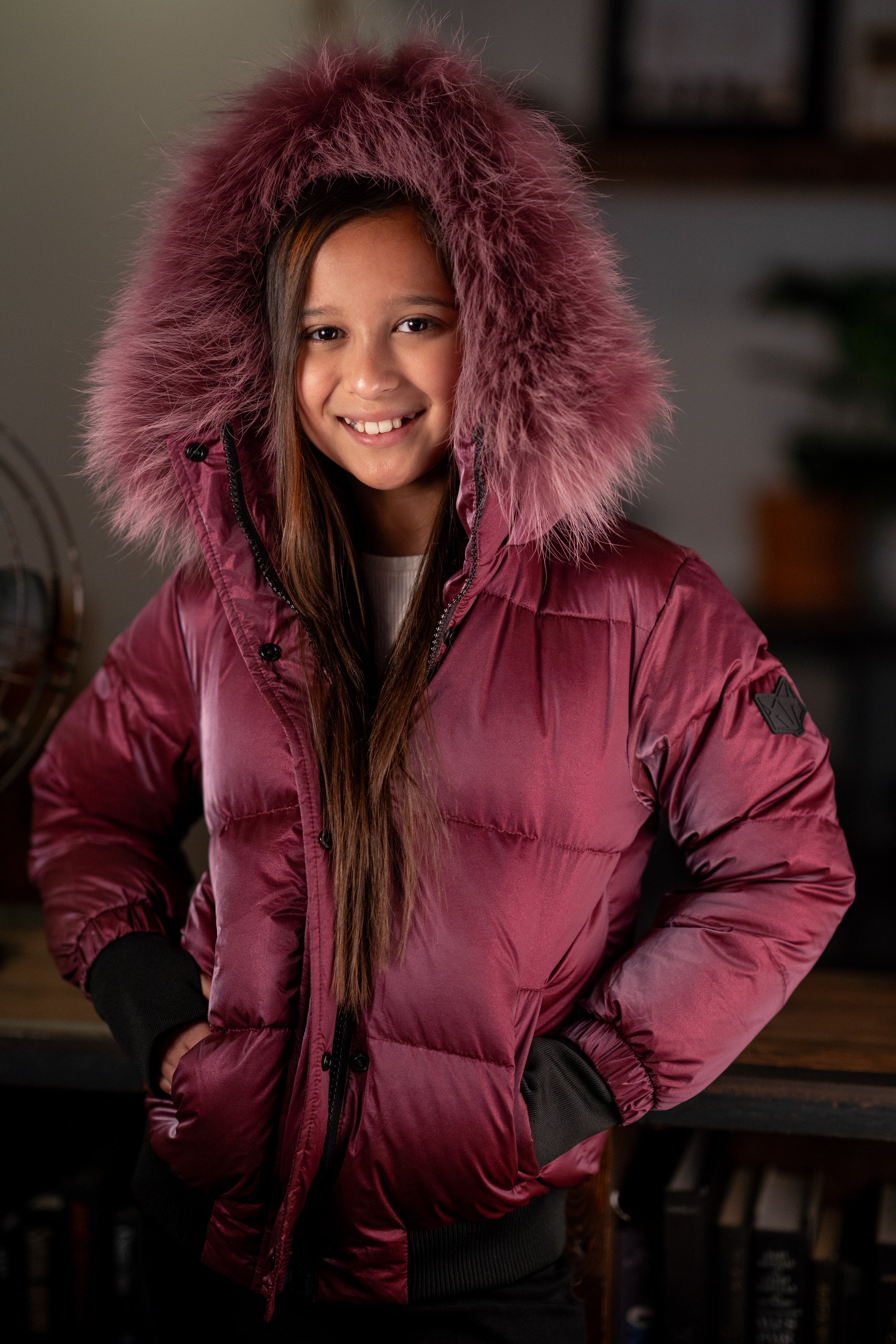 The Flamefruit coat featuring a luxurious racoon fur hood, sleek polyester exterior, and stylish design elements.