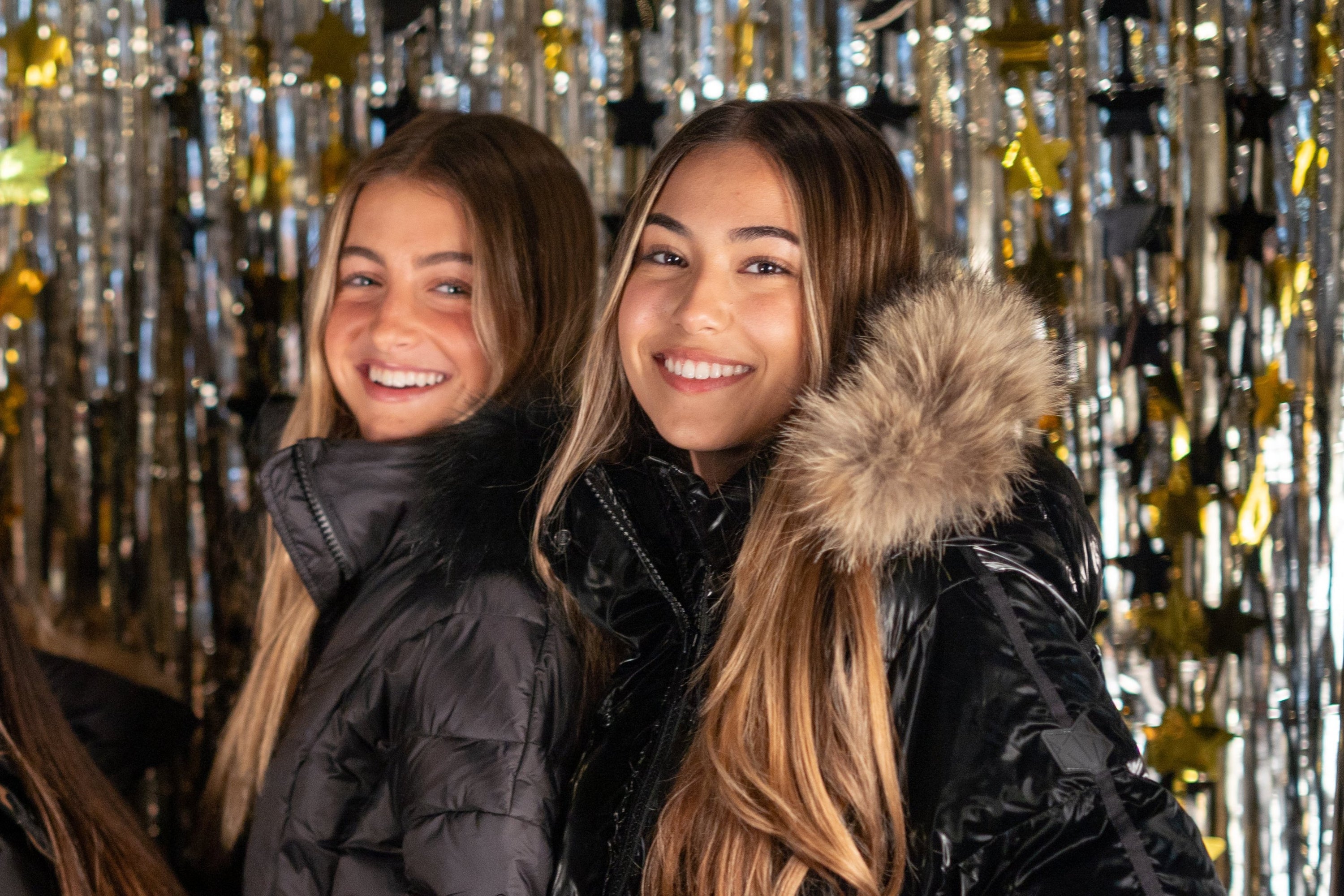 The Hay Wain black coat featuring a luxurious raccoon fur hood, fitted bomber style, and concealed zipper closure.