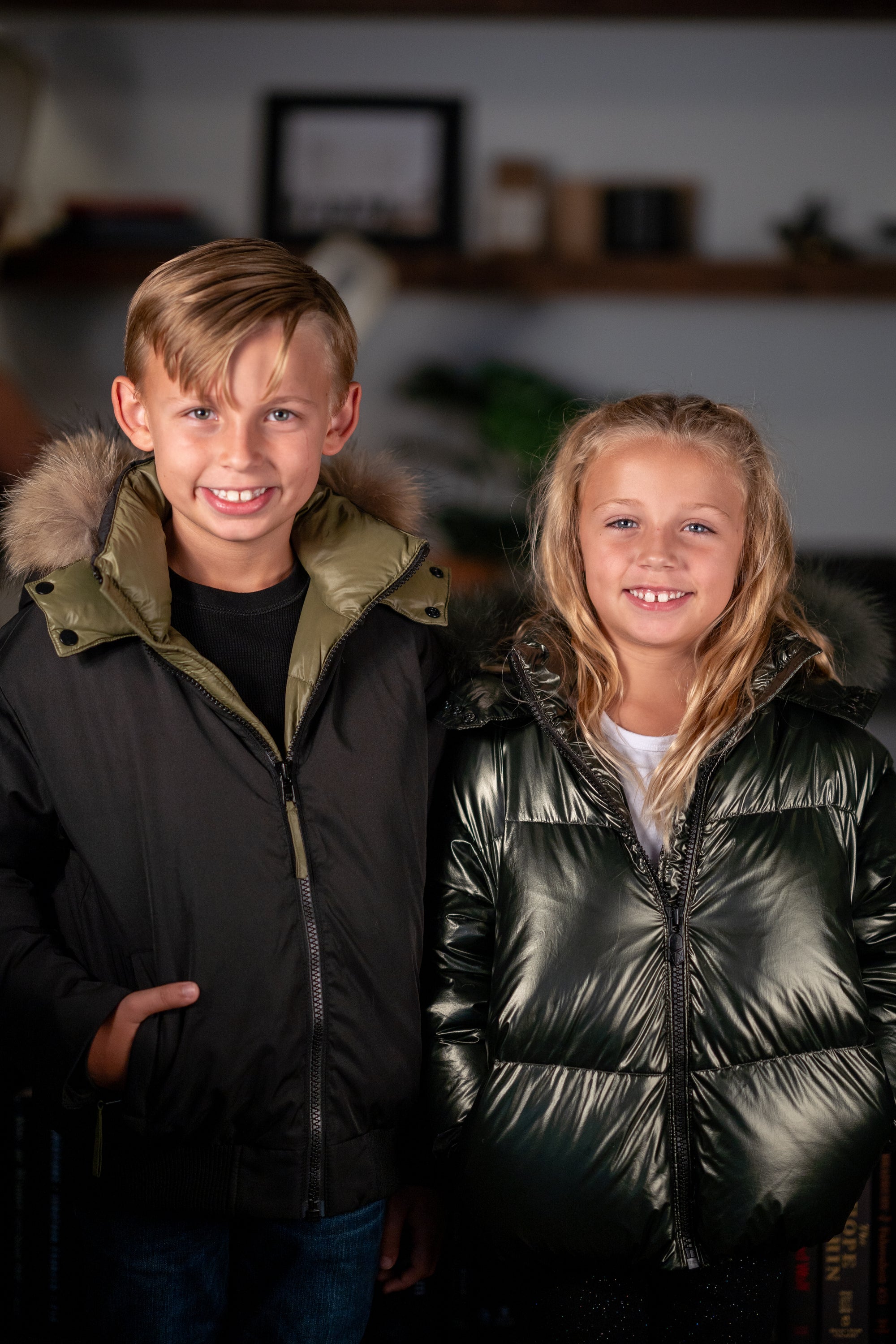 The Midnight Moss black coat featuring green lining, green toggles, and a luxurious raccoon fur hood, designed for warmth and style.