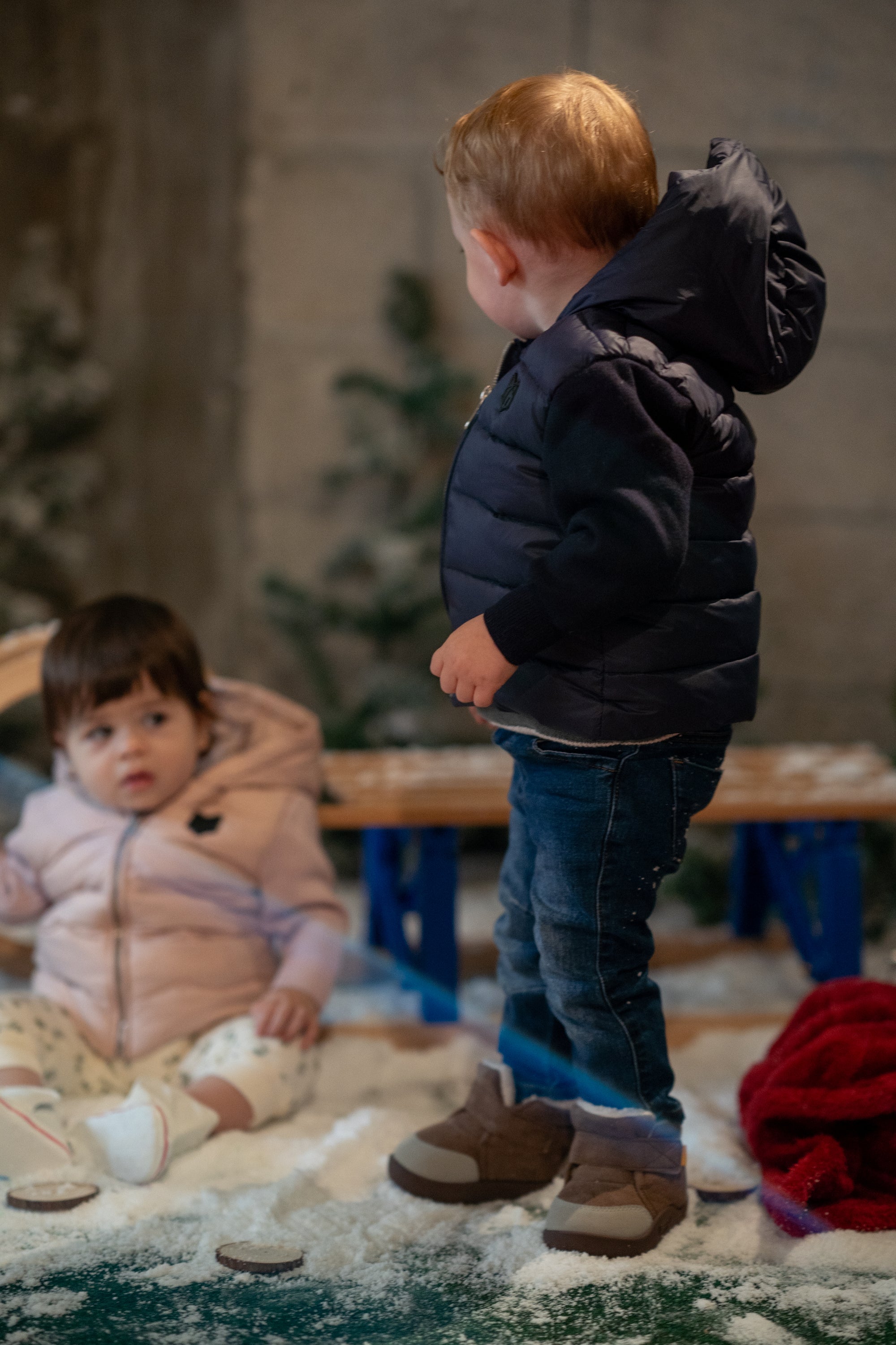 The Sullivan Navy Jacket featuring cozy knit sleeves, high collar, and hood, designed for boys, perfect for in-between weather.