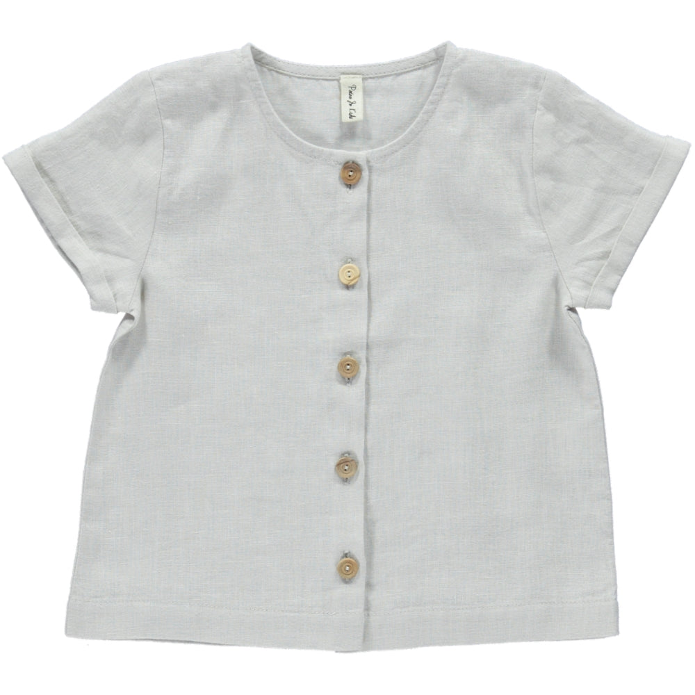 Top Petunia Creme featuring short sleeves, rolled cuffs, and olive wood buttons, made from soft natural linen fabric.