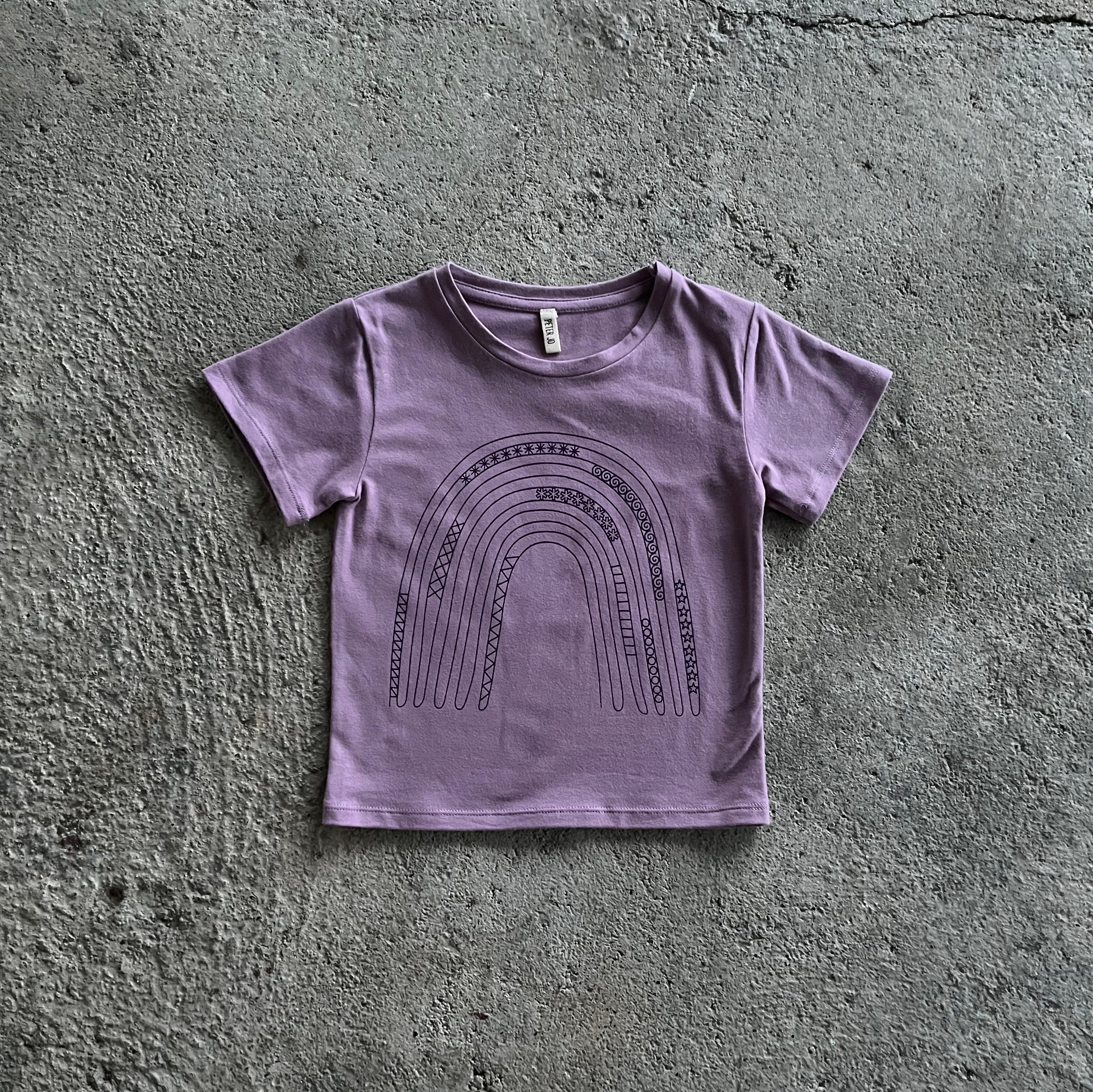 A vibrant purple T-shirt for babies and toddlers featuring a colorful rainbow print, perfect for casual wear.