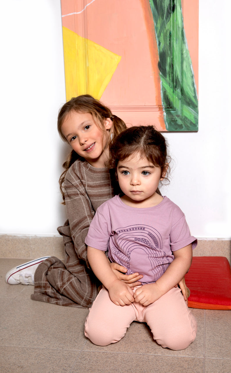 A vibrant purple T-shirt for babies and toddlers featuring a colorful rainbow print, perfect for casual wear.