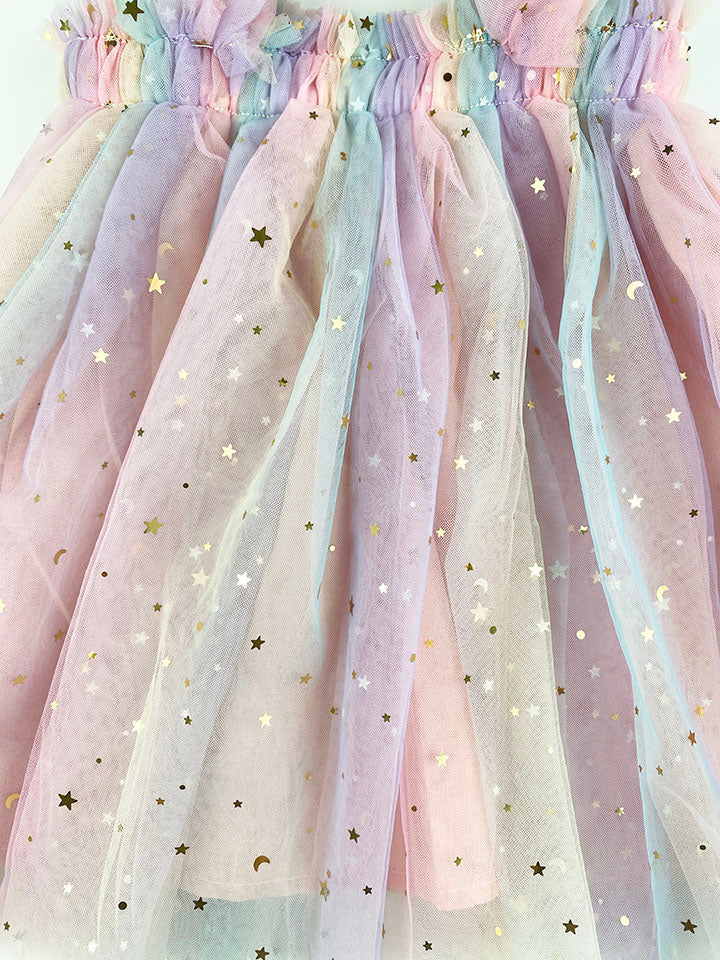 A beautiful tulle dress featuring a moon and stars print with a gradient of pastel colors including pink, purple, teal, and yellow.