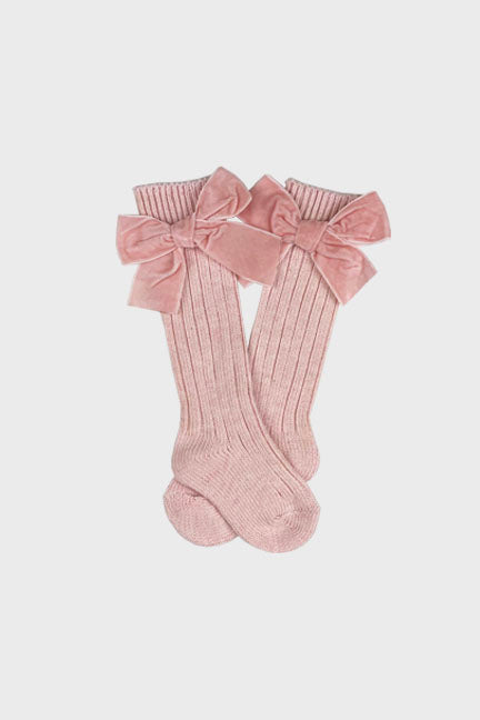 A pair of cozy velvet bow knee high socks in cinnamon color, featuring a cute velvet bow on the outer leg and ribbed design.