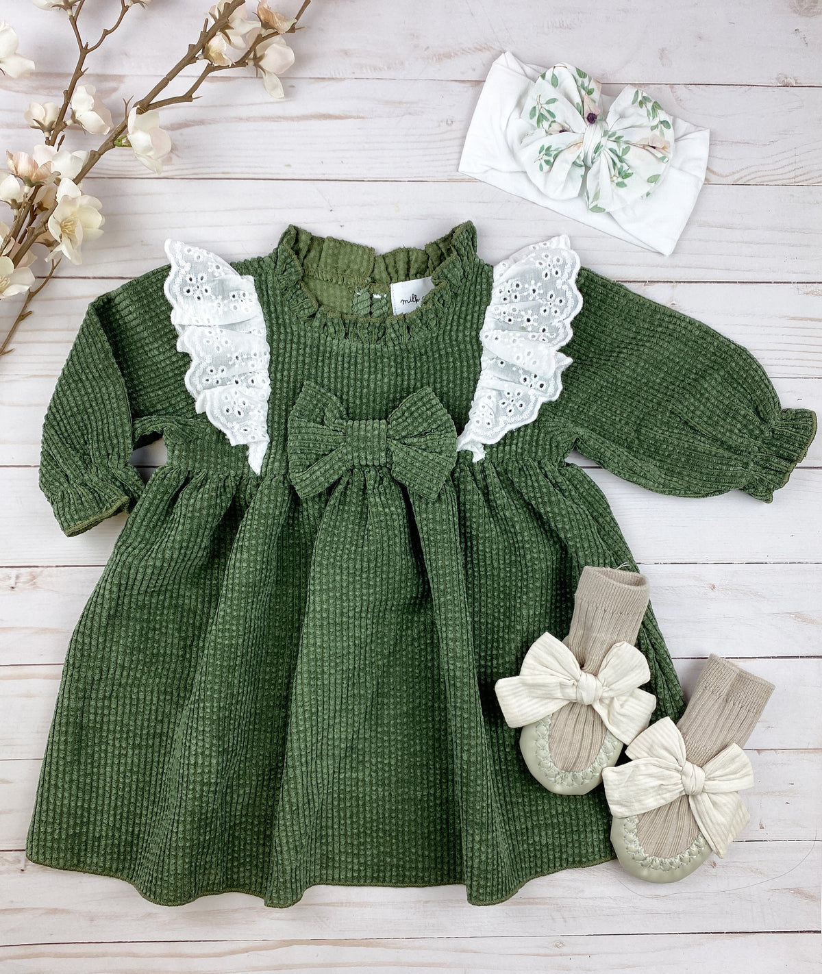 Wendy Corduroy Ruffle Dress in English Ivy green with lace details and bow, showcasing a soft ribbed texture.