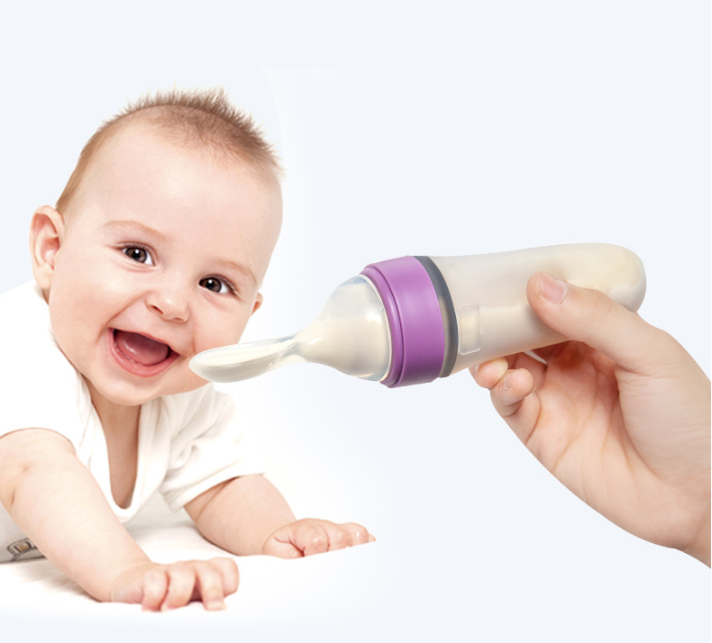 A purple silicone baby feeding bottle with a squeeze spoon, designed for easy feeding of cereals and semi-liquid foods.