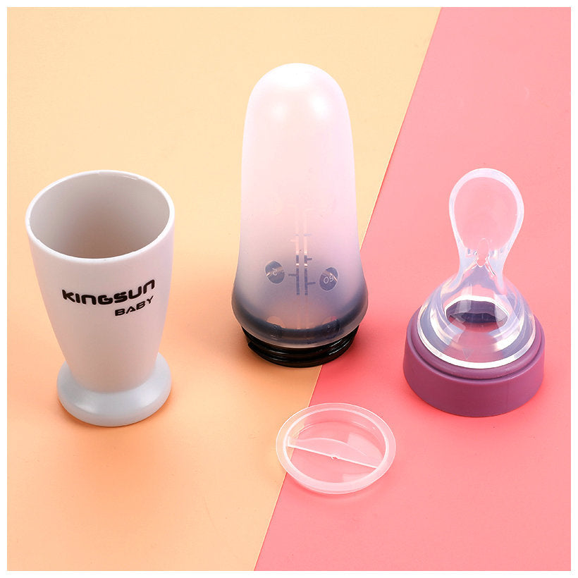A purple silicone baby feeding bottle with a squeeze spoon, designed for easy feeding of cereals and semi-liquid foods.