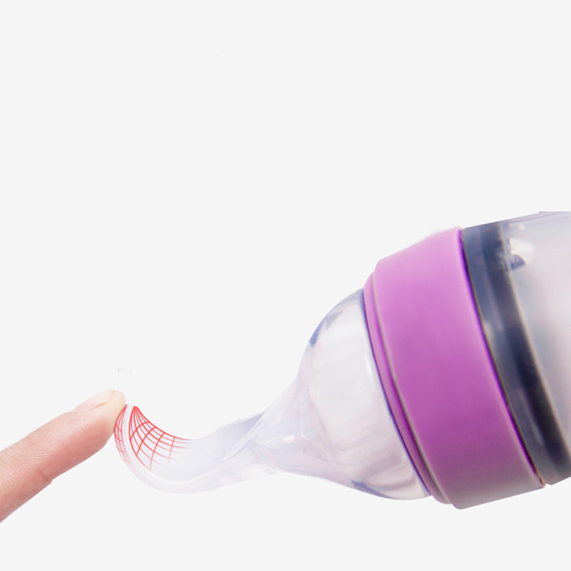 A purple silicone baby feeding bottle with a squeeze spoon, designed for easy feeding of cereals and semi-liquid foods.