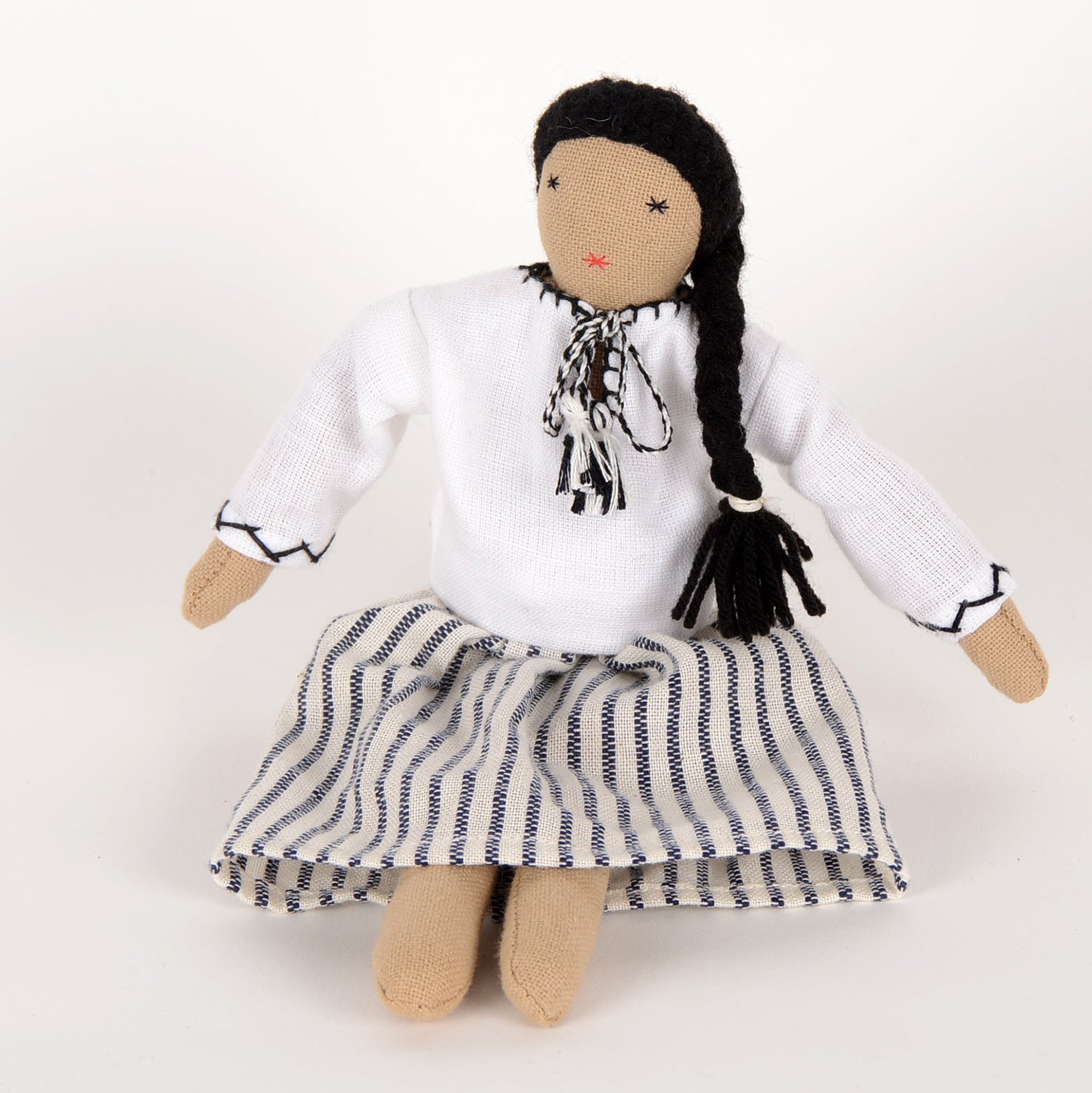 Mini Maya doll handcrafted by Afghan artisans, featuring a long skirt, long-sleeved blouse, and braided hair, packaged in a foldable box.