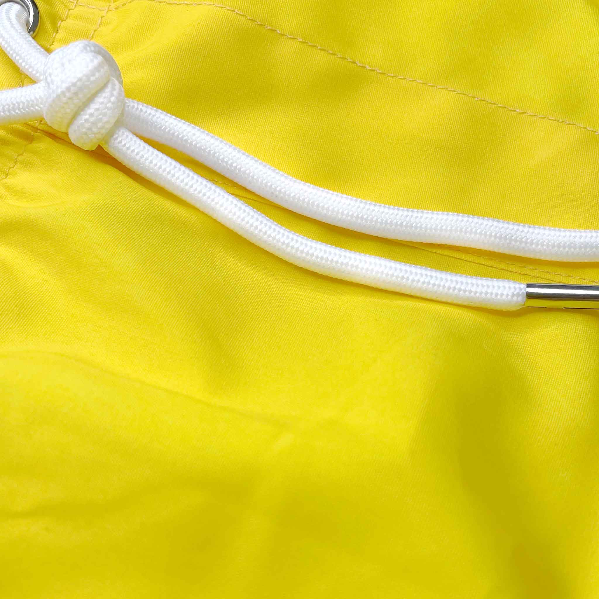 Color-changing swim trunks transitioning from yellow to orange in water, showcasing eco-friendly fabric and stylish design.