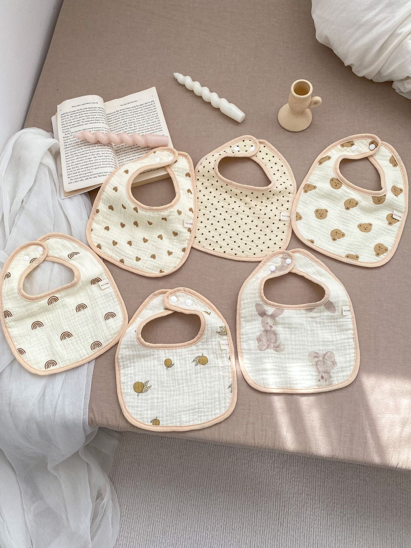 Adorable U-shaped cotton muslin bib featuring cute cartoon designs, perfect for babies.