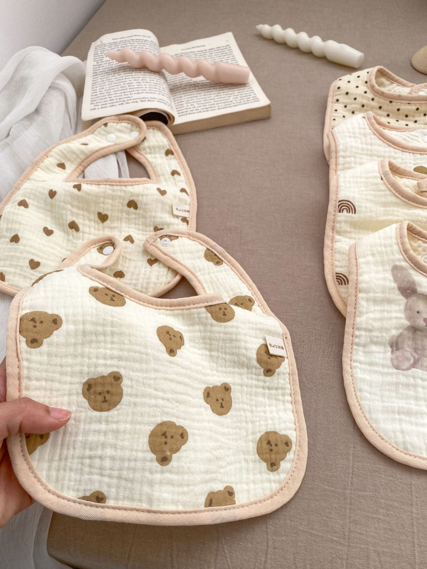 Adorable U-shaped cotton muslin bib featuring cute cartoon designs, perfect for babies.