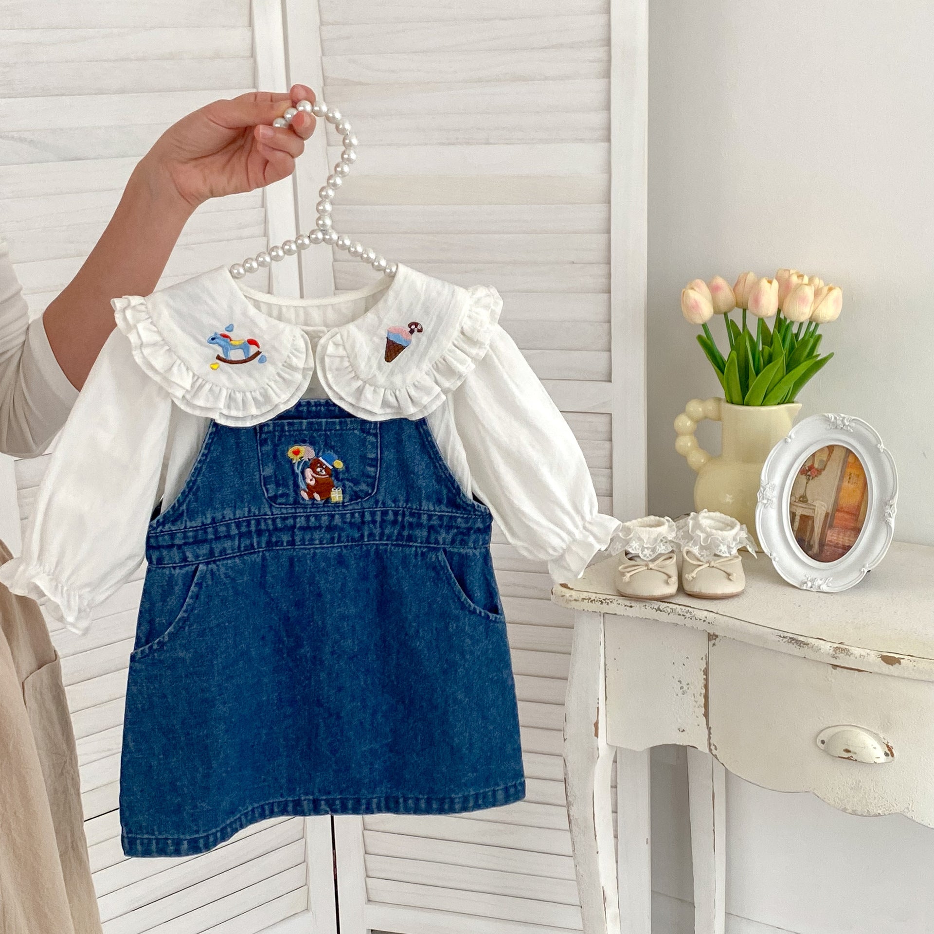 A cute blue and beige long sleeves top for baby girls featuring cartoon embroidery patterns, perfect for autumn and spring wear.