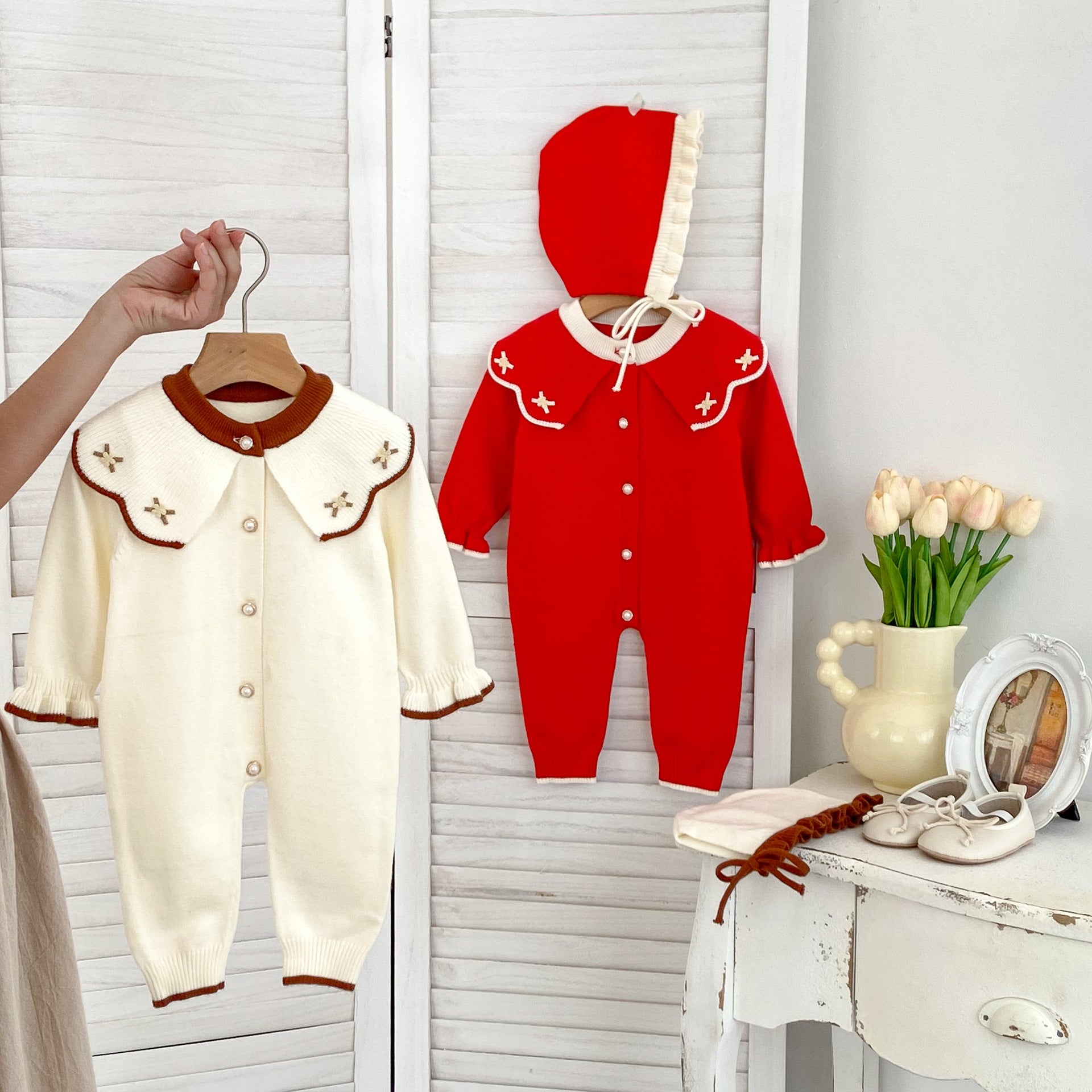 A cozy knitted top for baby girls featuring long sleeves, a floral pattern collar, available in red and apricot colors.