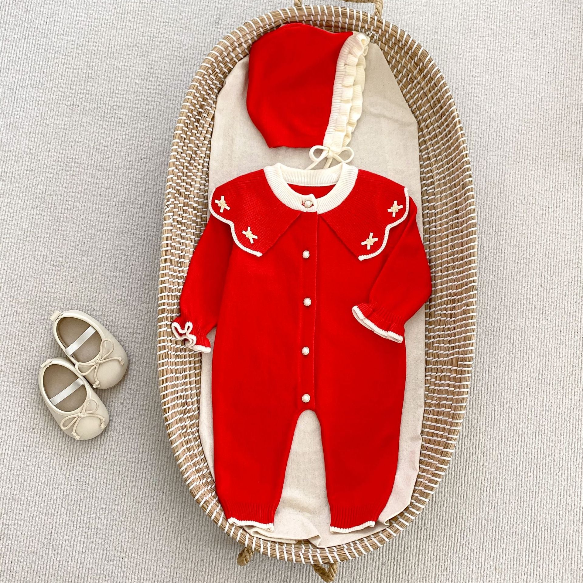 A cozy knitted top for baby girls featuring long sleeves, a floral pattern collar, available in red and apricot colors.