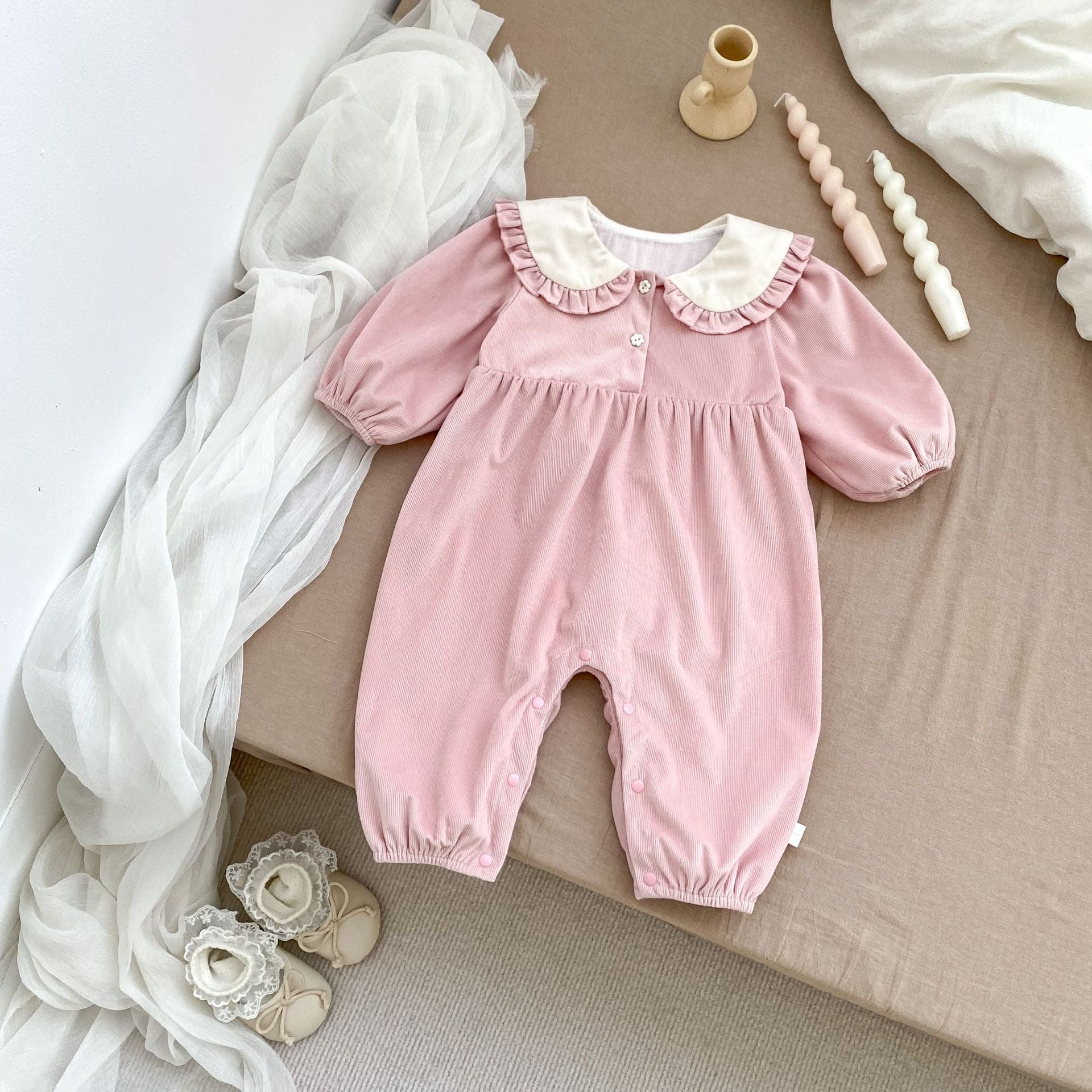 A cute baby girl wearing a long sleeves romper with a rabbits design in pink color, perfect for autumn.