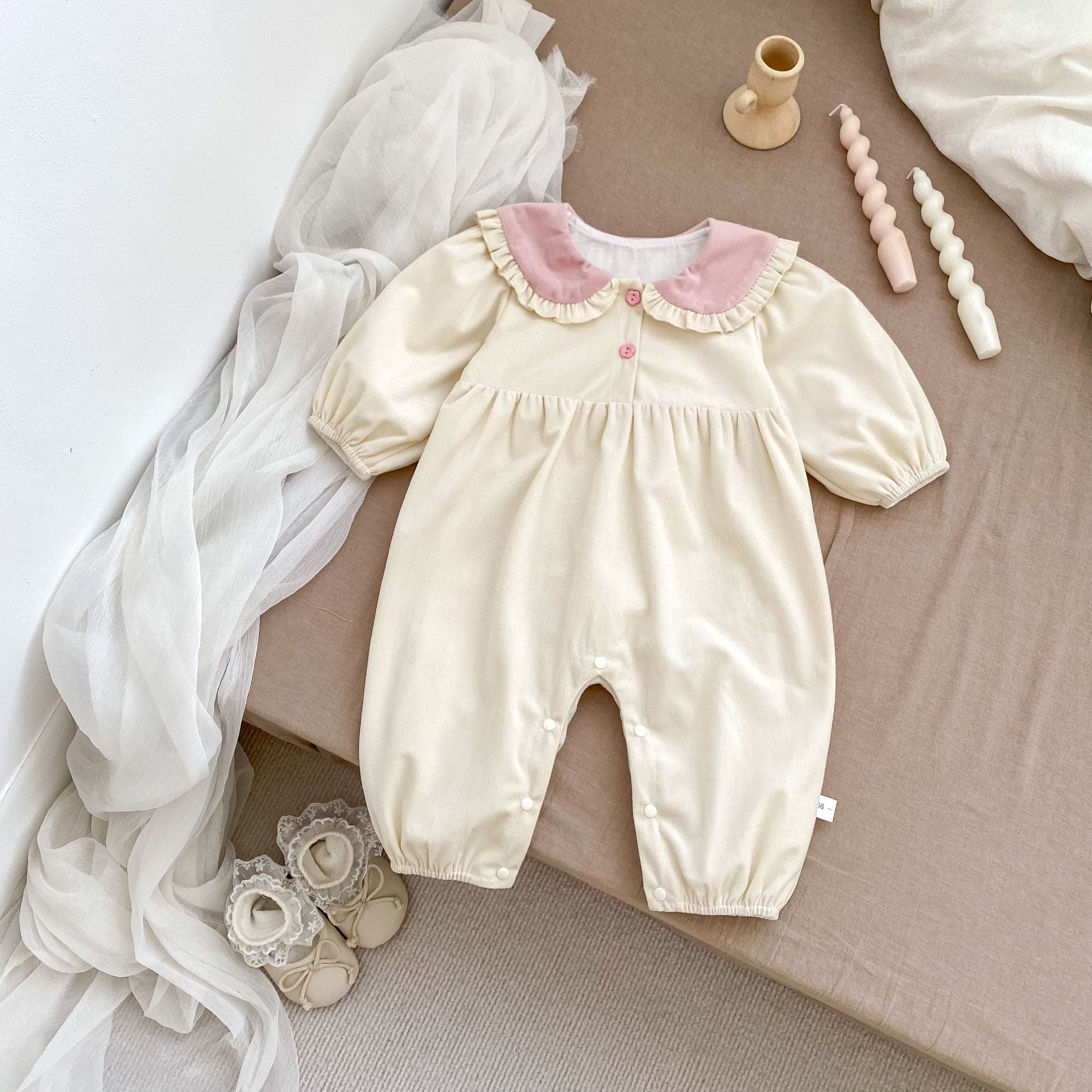 A cute baby girl wearing a long sleeves romper with a rabbits design in pink color, perfect for autumn.