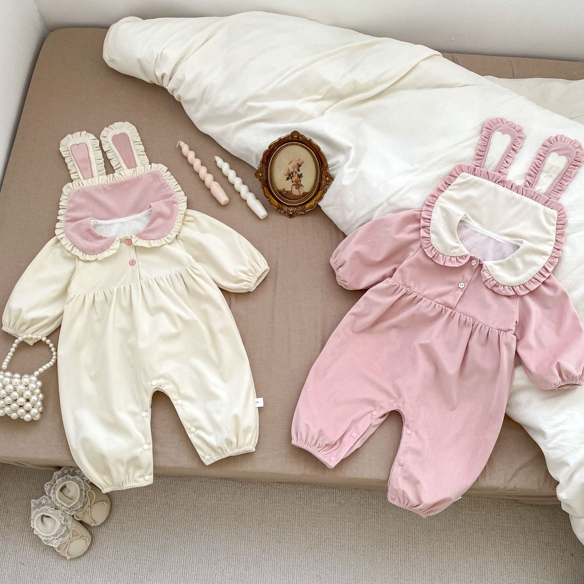 A cute baby girl wearing a long sleeves romper with a rabbits design in pink color, perfect for autumn.