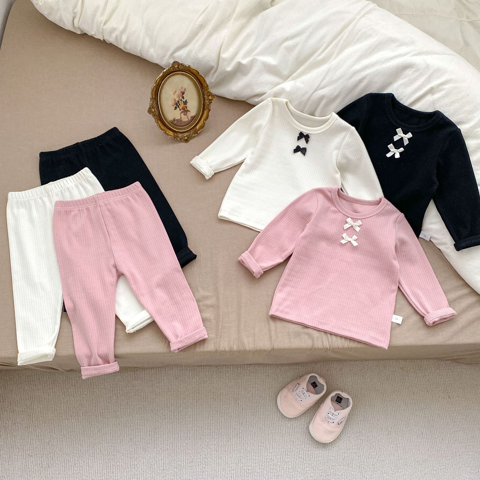 A cozy Arrival Autumn Baby Girls Long Sleeves Simple Knitted Top in black, pink, and beige, showcasing its soft cotton fabric and stylish design.