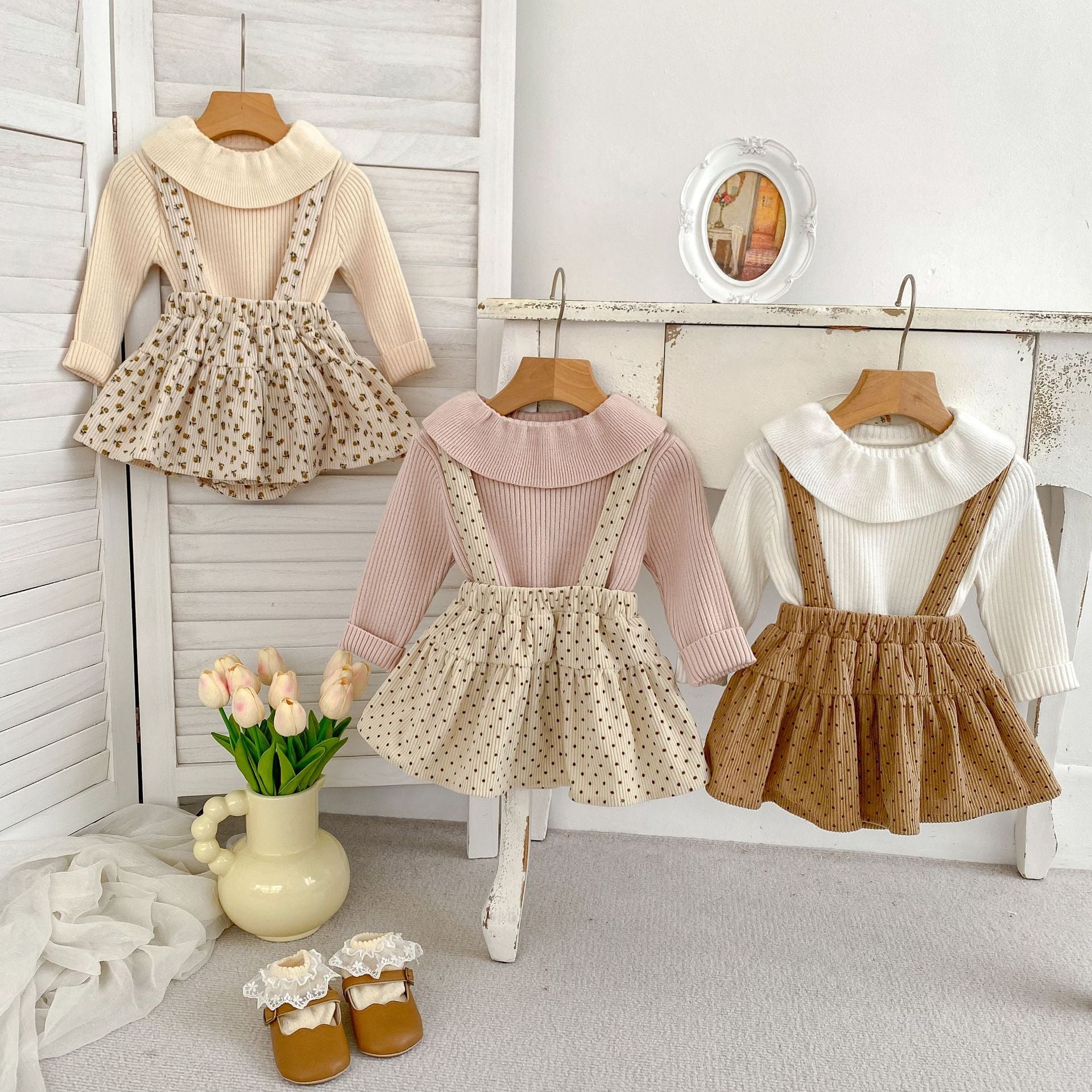 A stylish autumn outfit for baby girls featuring a long-sleeve top and cute overalls in various colors and patterns.