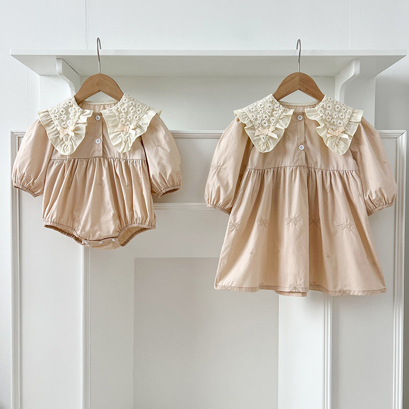 A pink long-sleeve top for baby girls featuring bows and floral embroidery, perfect for autumn and spring wear.