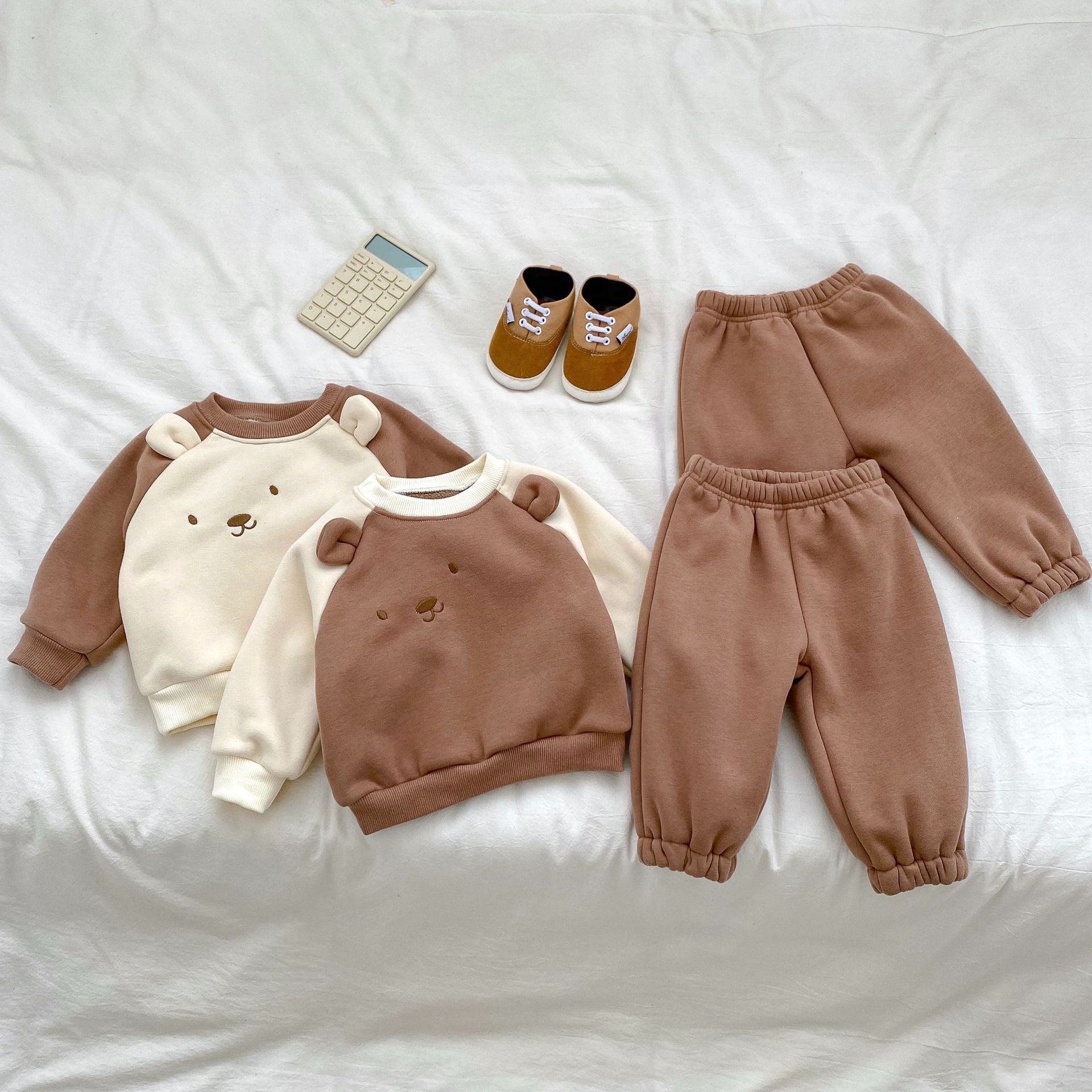 A beige and brown long sleeve pullover for babies featuring a cute bear design, perfect for autumn and winter wear.