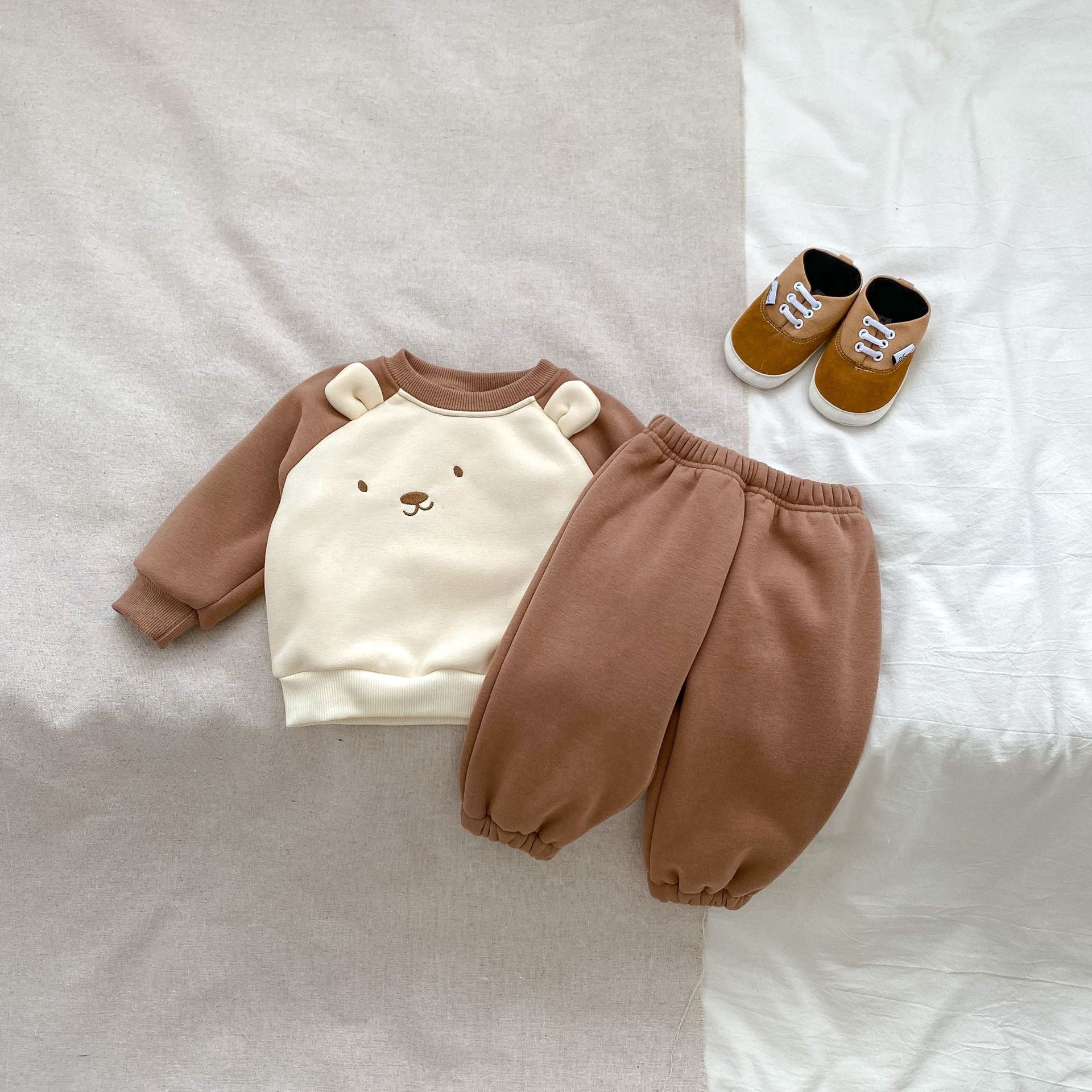 A beige and brown long sleeve pullover for babies featuring a cute bear design, perfect for autumn and winter wear.