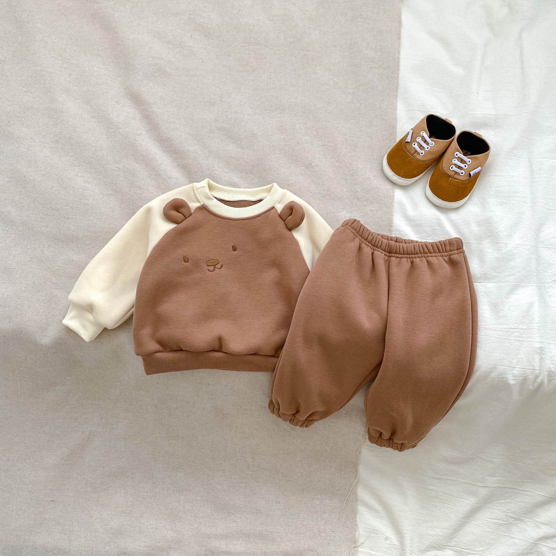 A beige and brown long sleeve pullover for babies featuring a cute bear design, perfect for autumn and winter wear.