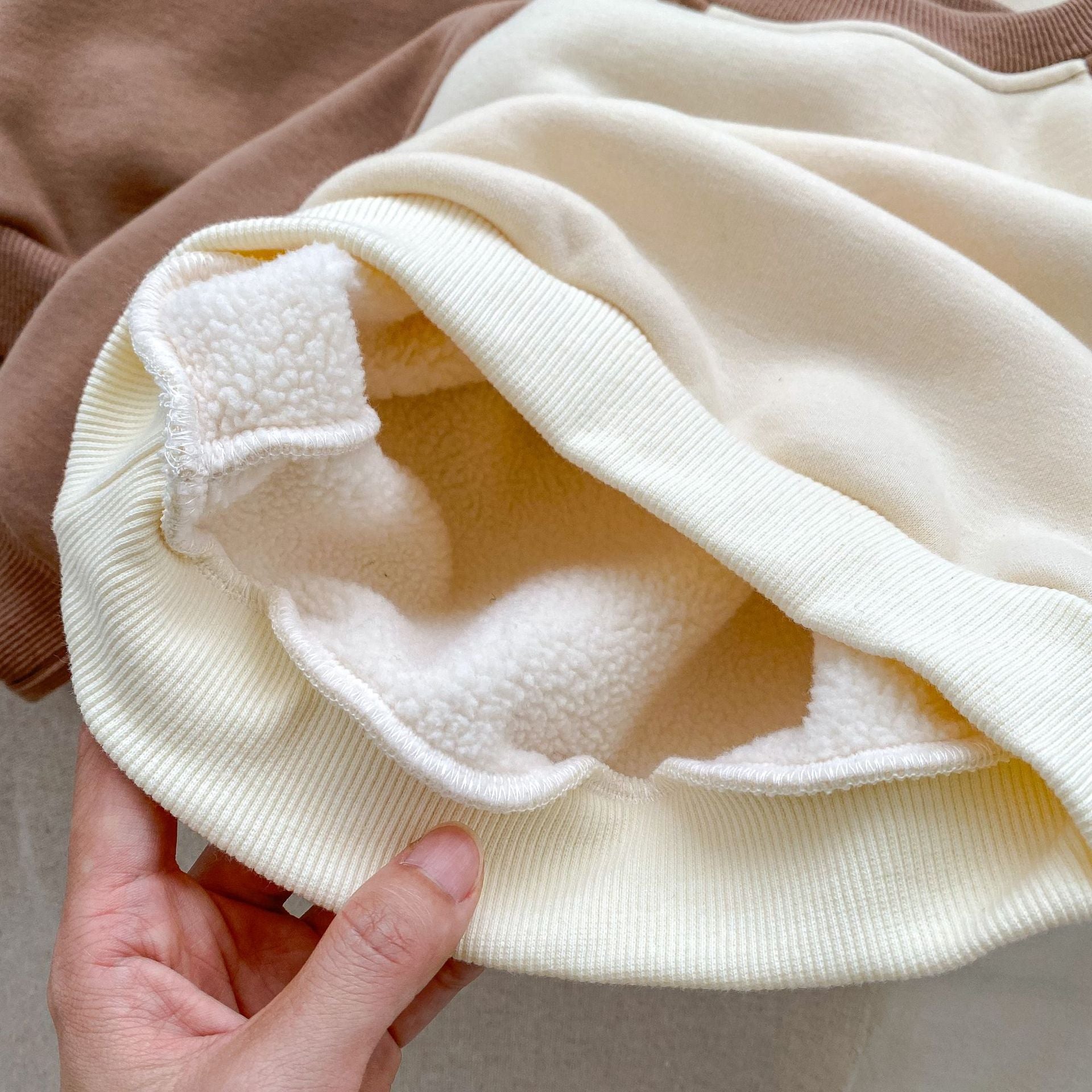 A beige and brown long sleeve pullover for babies featuring a cute bear design, perfect for autumn and winter wear.