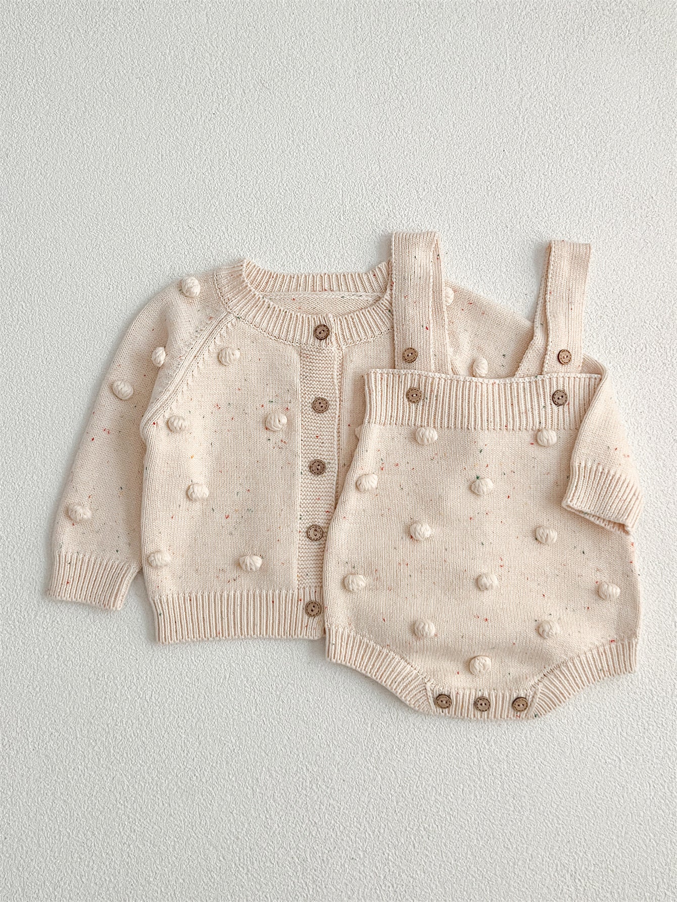 A cozy apricot knitted cardigan for babies with long sleeves, perfect for autumn and spring wear.