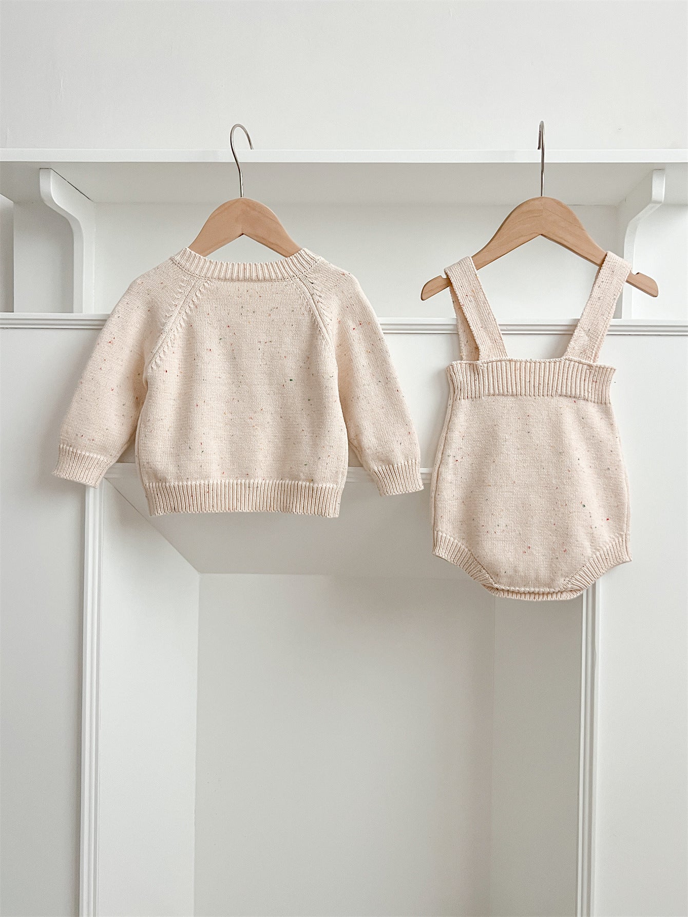 A cozy apricot knitted cardigan for babies with long sleeves, perfect for autumn and spring wear.