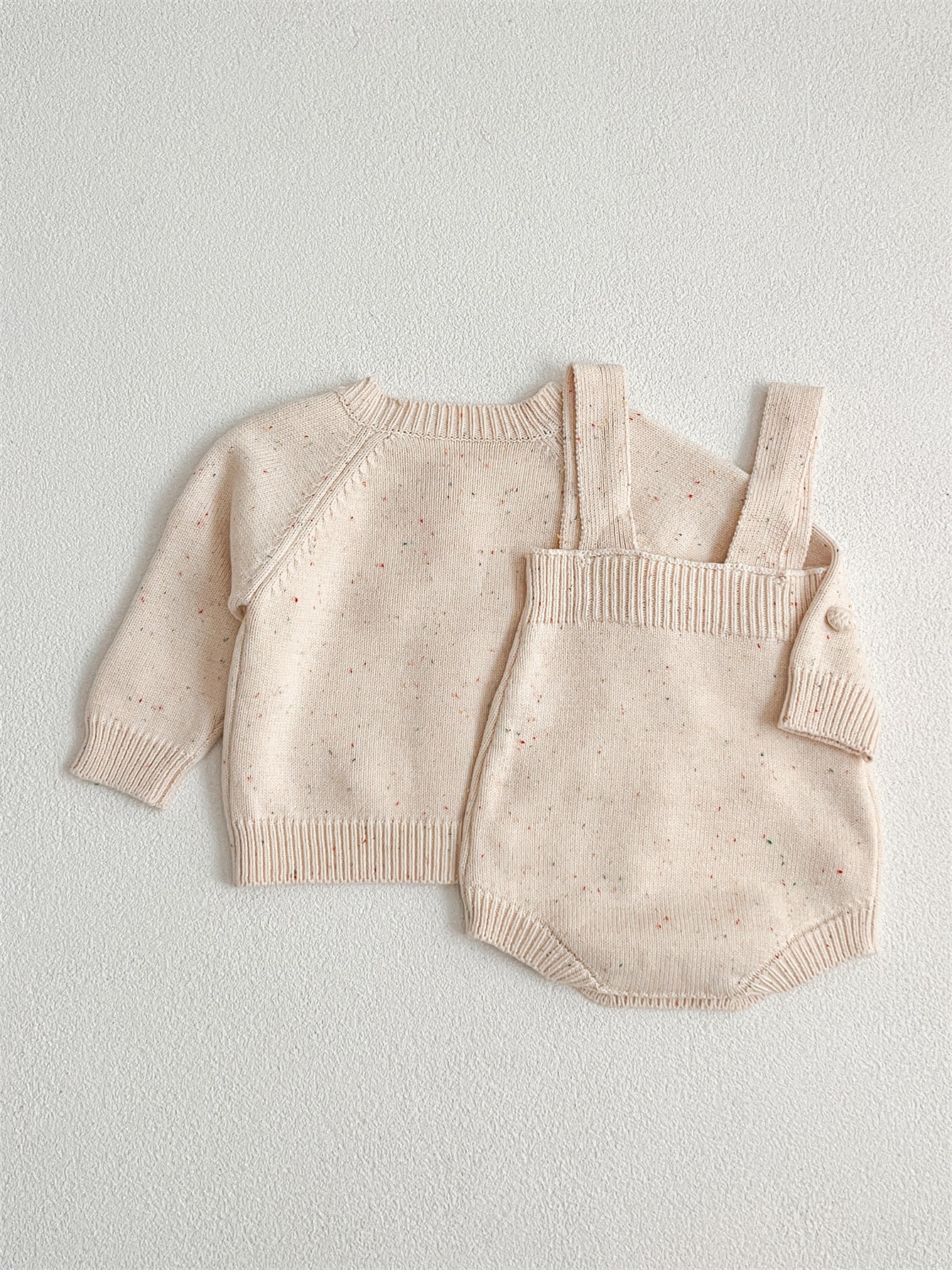 A cozy apricot knitted cardigan for babies with long sleeves, perfect for autumn and spring wear.