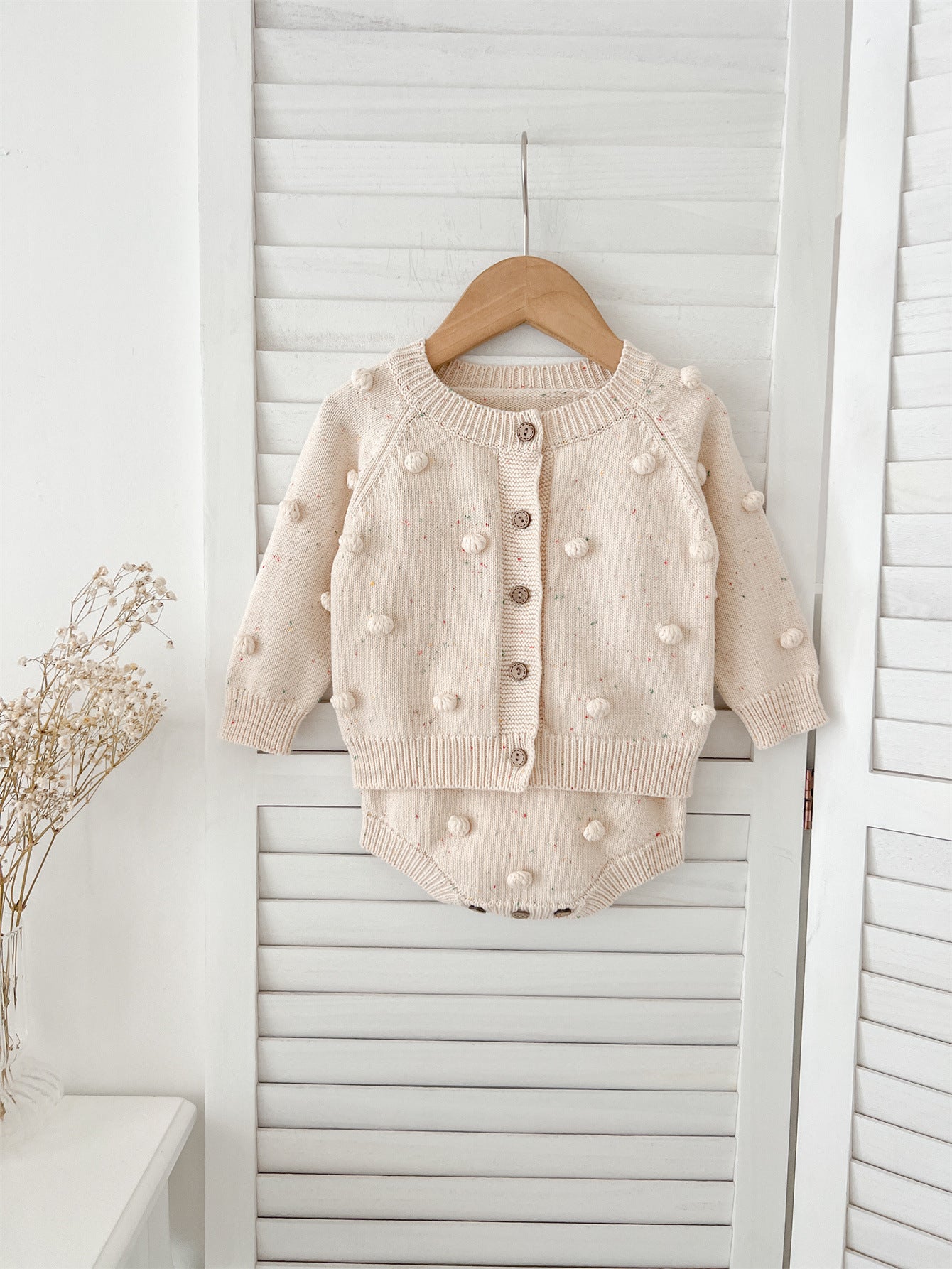 A cozy apricot knitted cardigan for babies with long sleeves, perfect for autumn and spring wear.