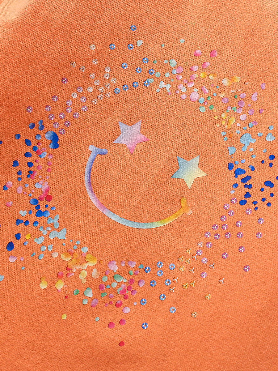 Bright orange long sleeve shirt for girls featuring a smiling face cartoon pattern, made from soft cotton material.