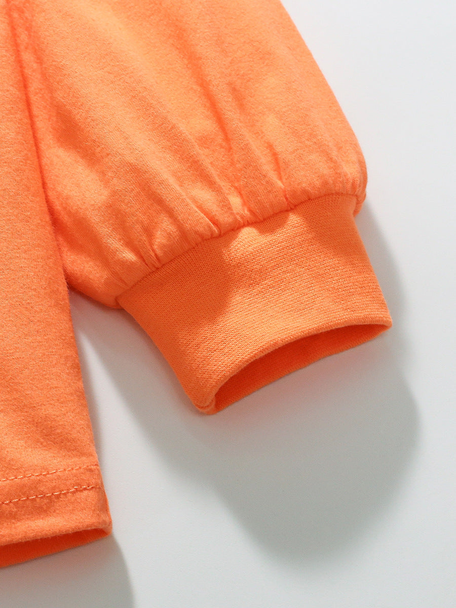 Bright orange long sleeve shirt for girls featuring a smiling face cartoon pattern, made from soft cotton material.