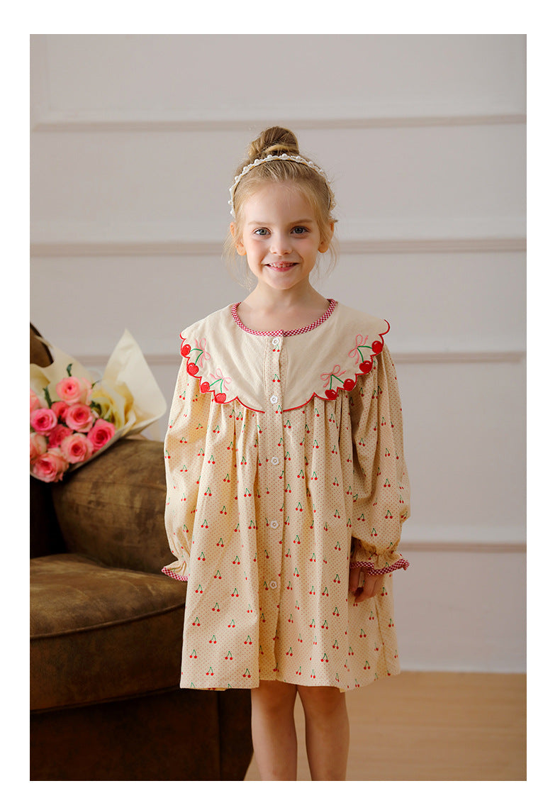 A charming long-sleeved dress for girls featuring a playful cherry pattern, made from soft cotton in apricot color.